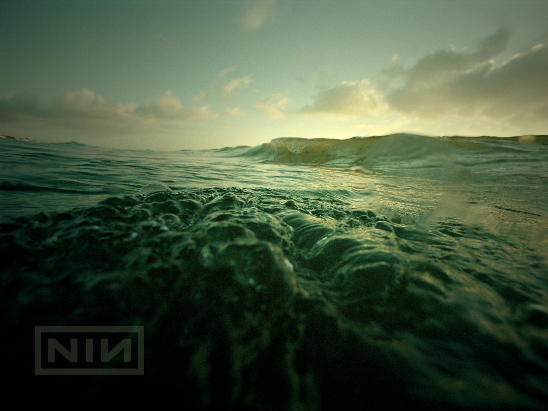 Nine Inch Nails logo over ocean waves at sunset HD Wallpaper