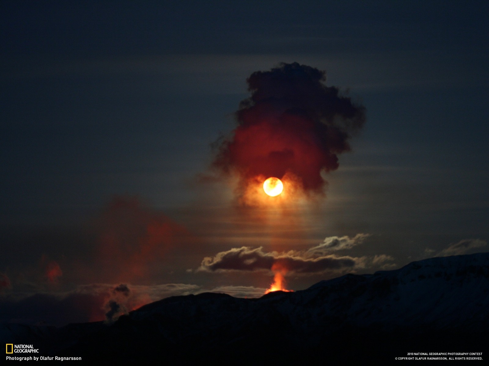 Volcanic eruption at sunset with sun obscured by smoke HD Wallpaper