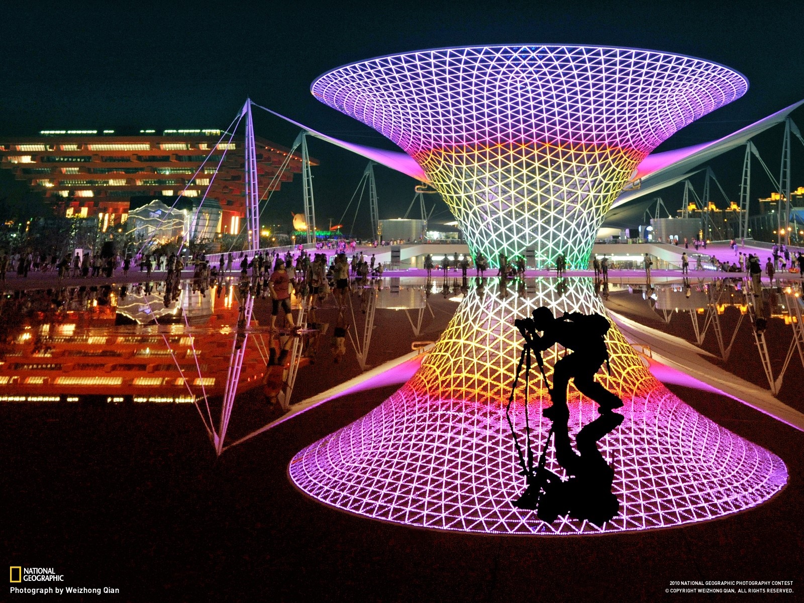 Night view of a colorful illuminated structure with a photographer HD Wallpaper
