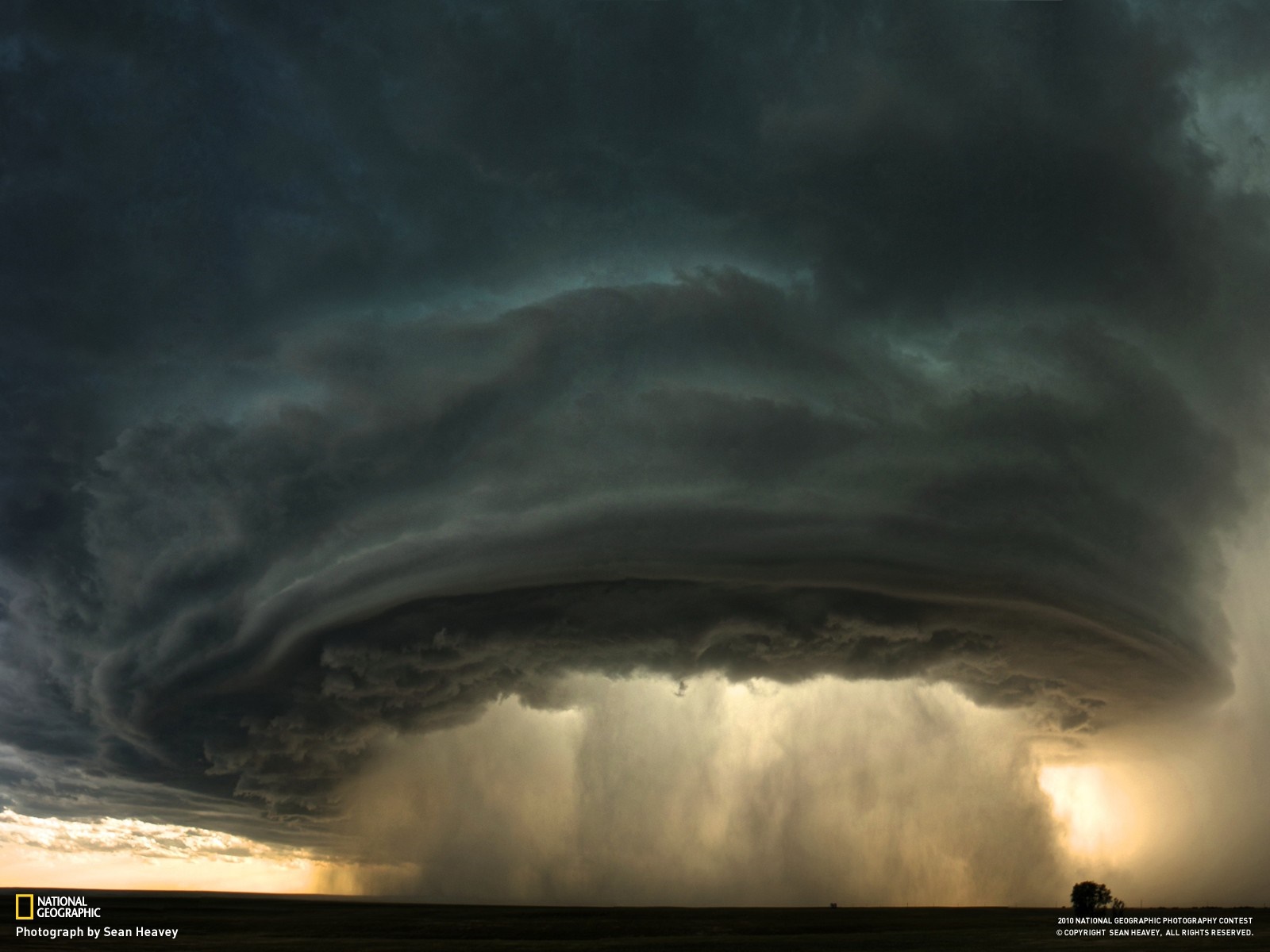Storm clouds with rain and lightning over a field HD Wallpaper