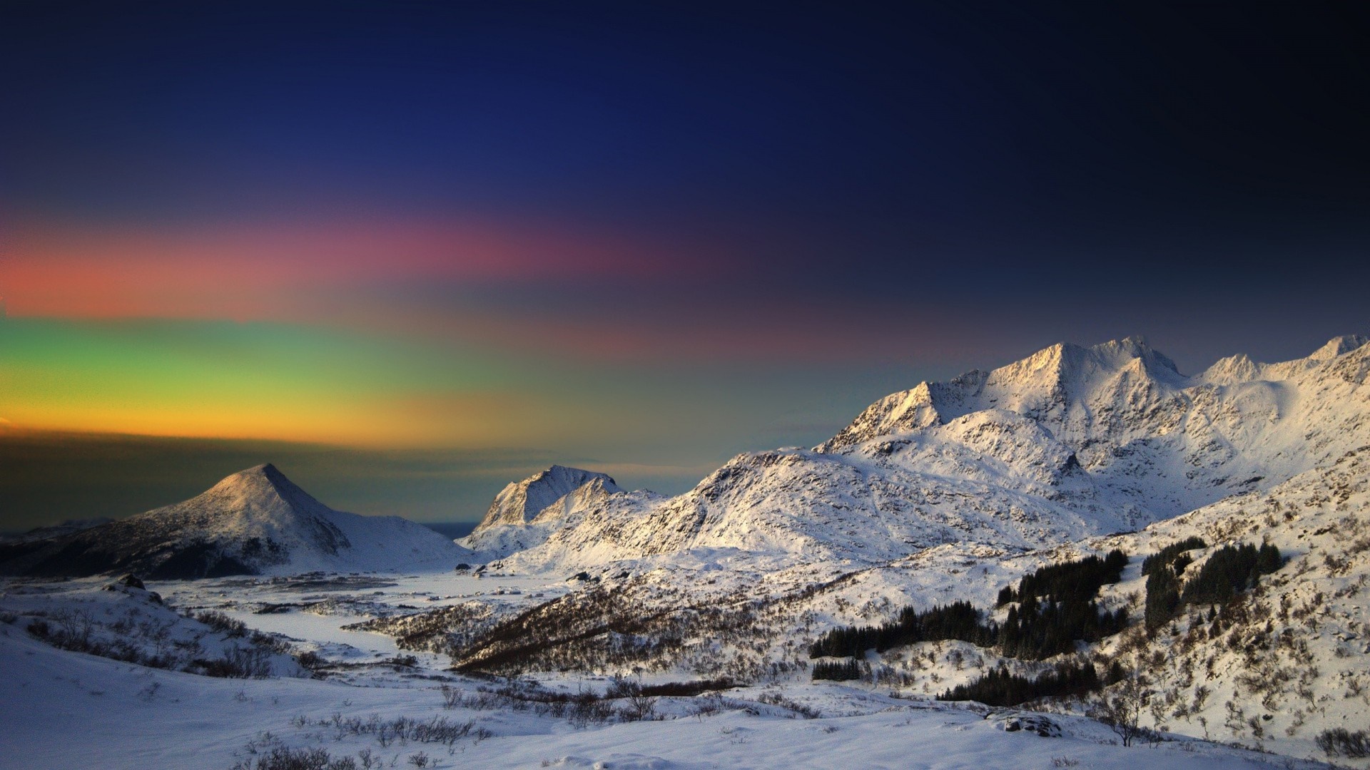 Snowy mountains under a colorful sky HD Wallpaper