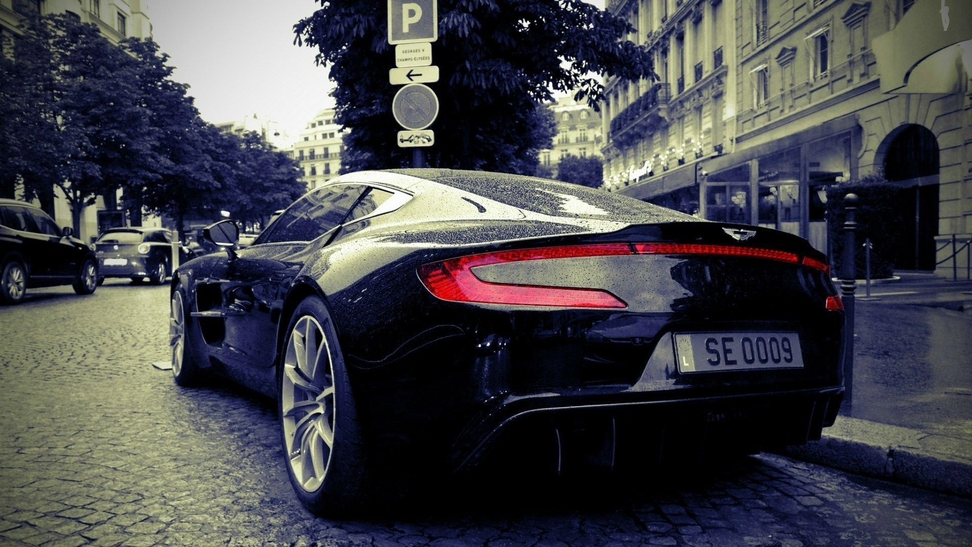 Black Aston Martin Vanquish parked on cobblestone street HD Wallpaper