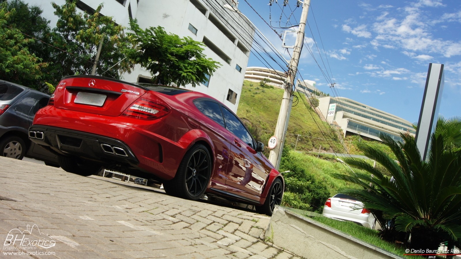 Red Mercedes-Benz C63 AMG Coupe parked on a street HD Wallpaper