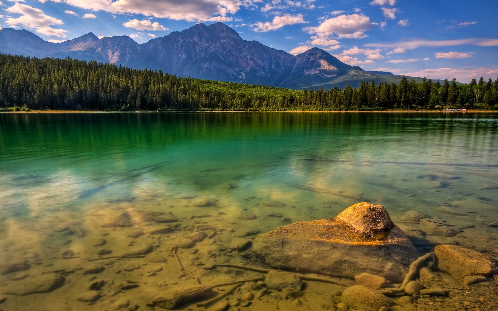 Clear lake with rocky bottom and mountains in the background HD Wallpaper