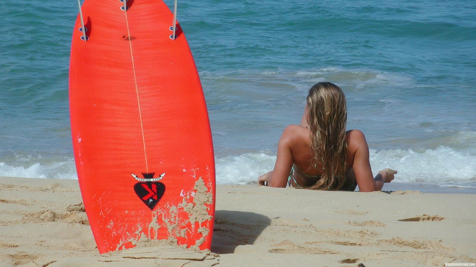 Woman and surfboard on a sandy beach with ocean waves HD Wallpaper