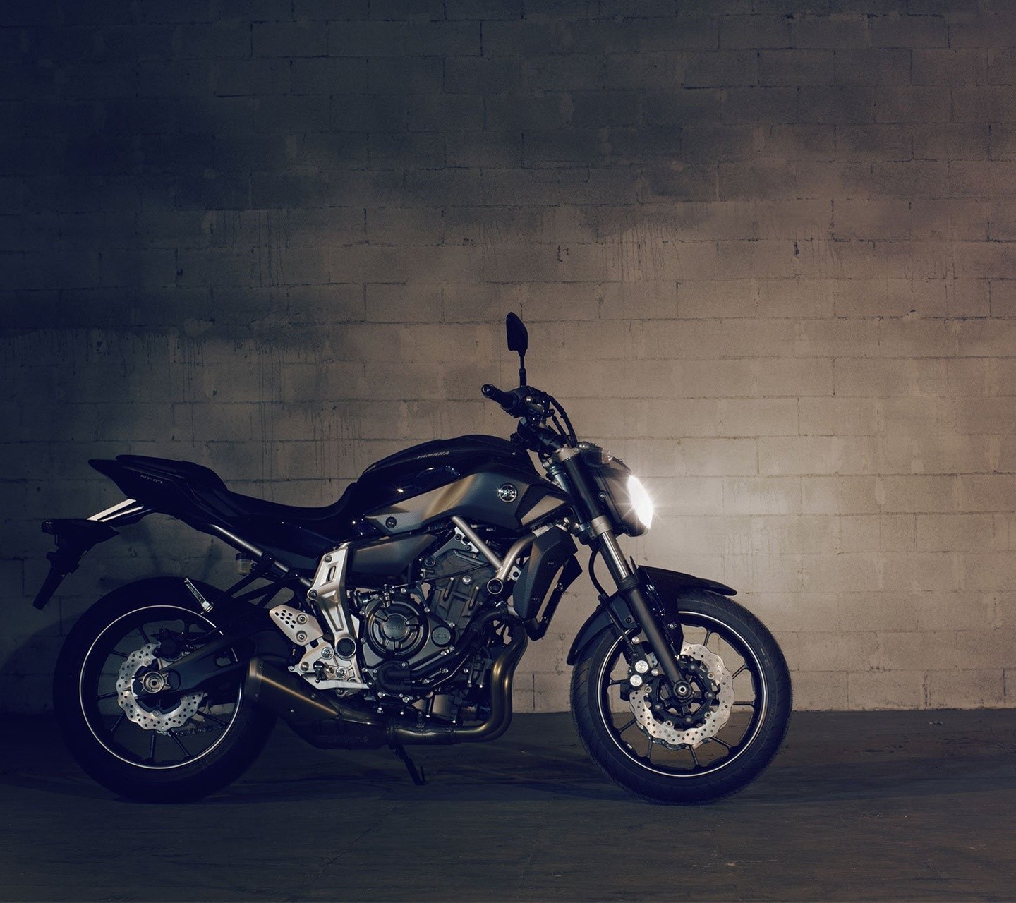 Black Yamaha motorcycle parked against a brick wall HD Wallpaper