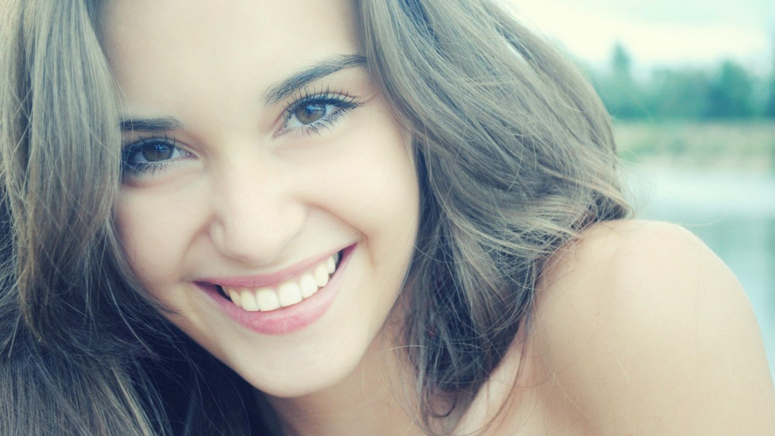 Close-up portrait of a smiling woman with brown hair HD Wallpaper
