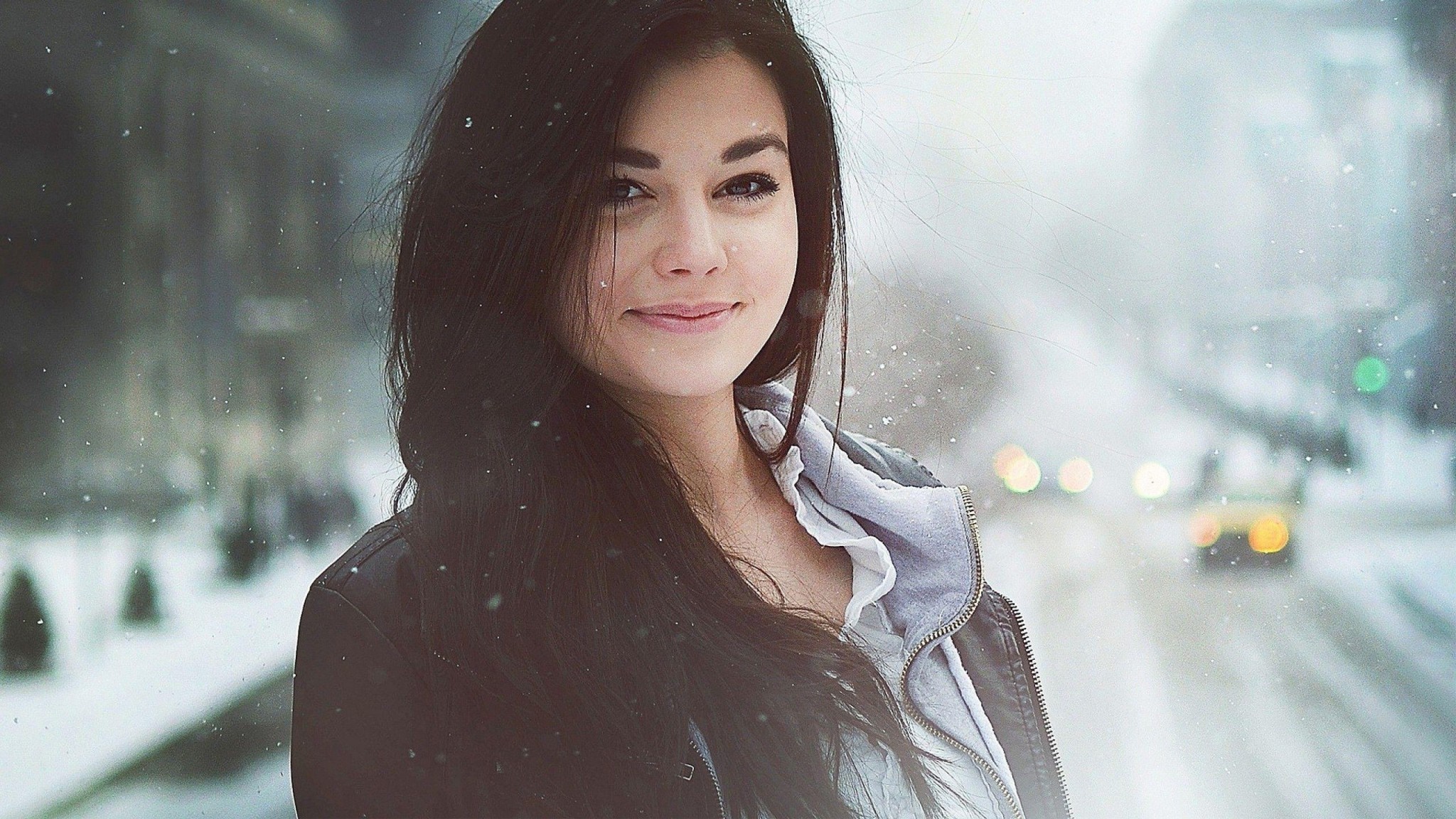 Woman with long dark hair smiling in the snow HD Wallpaper