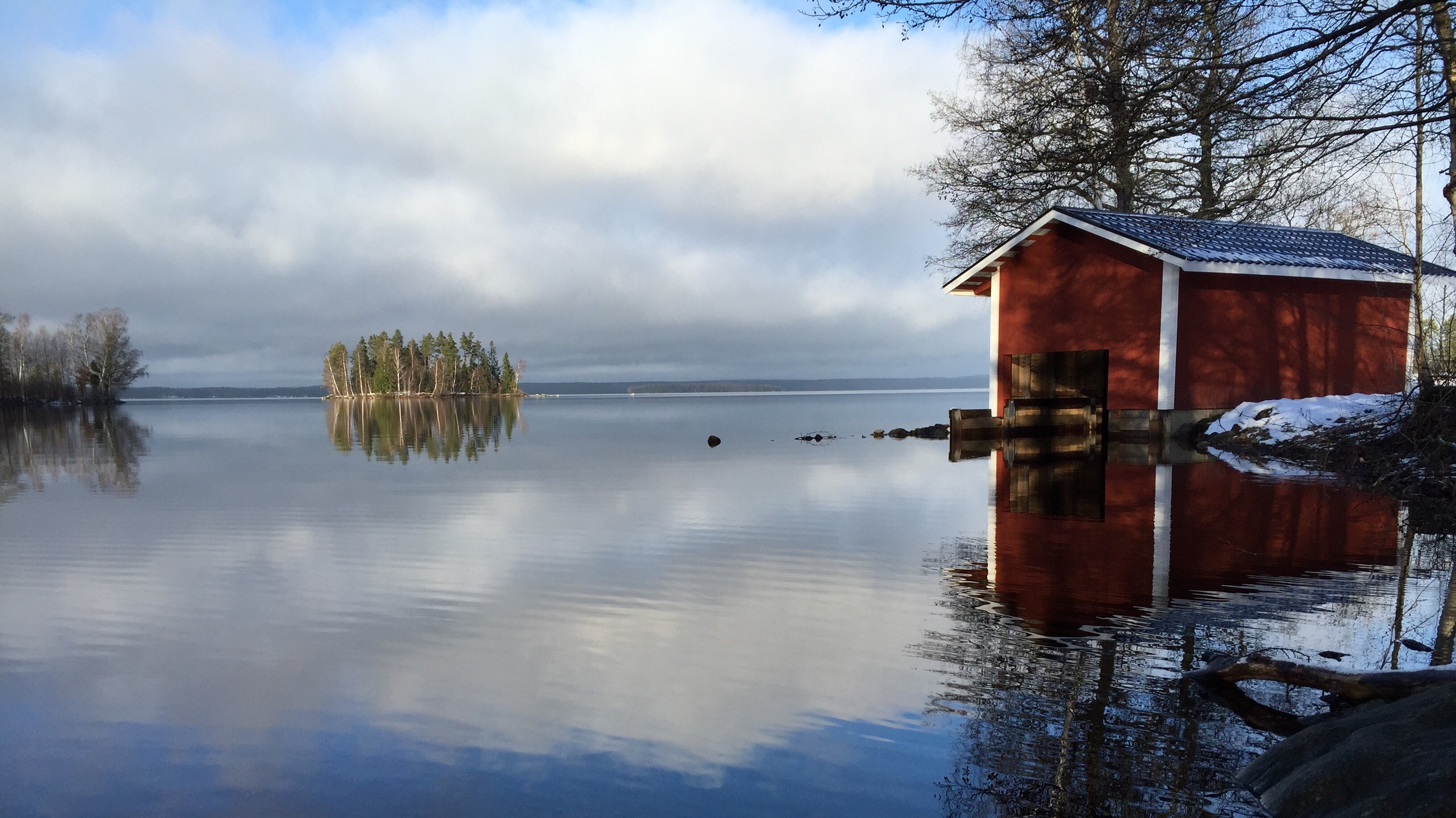Red boathouse on a calm lake with island reflection HD Wallpaper