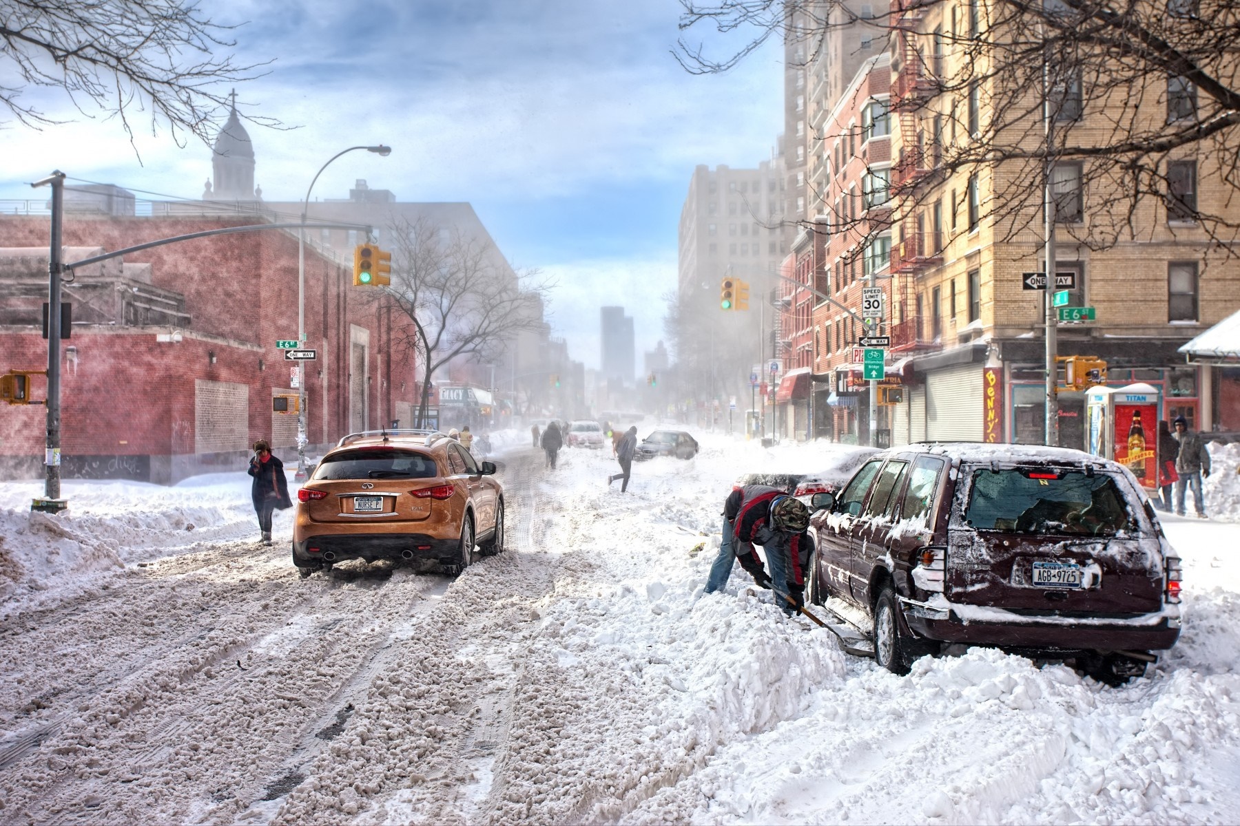 City street covered in snow during a blizzard with cars and people HD Wallpaper