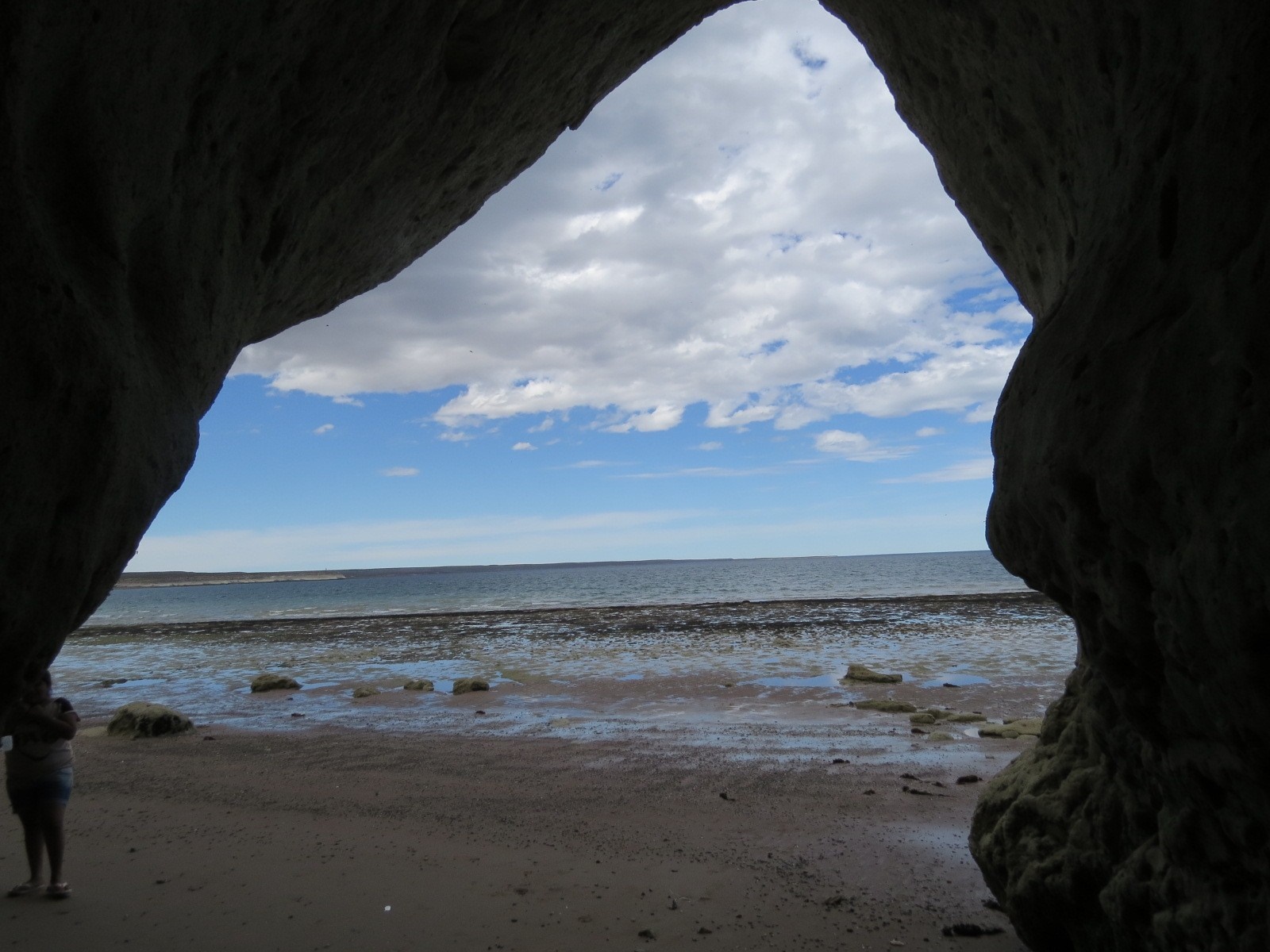 View of the sea and beach from inside a cave HD Wallpaper