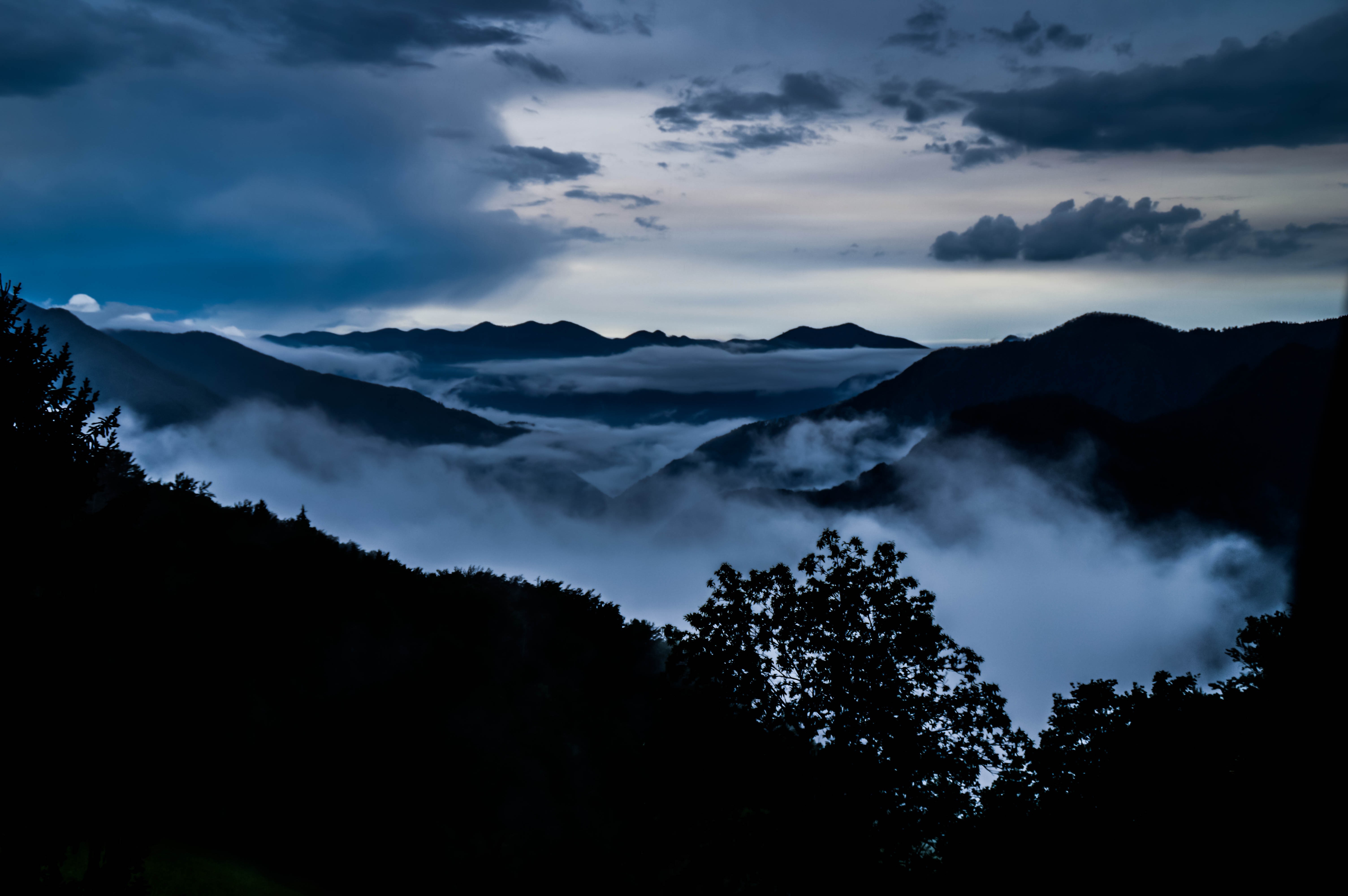 Misty mountains at dusk with dark clouds HD Wallpaper