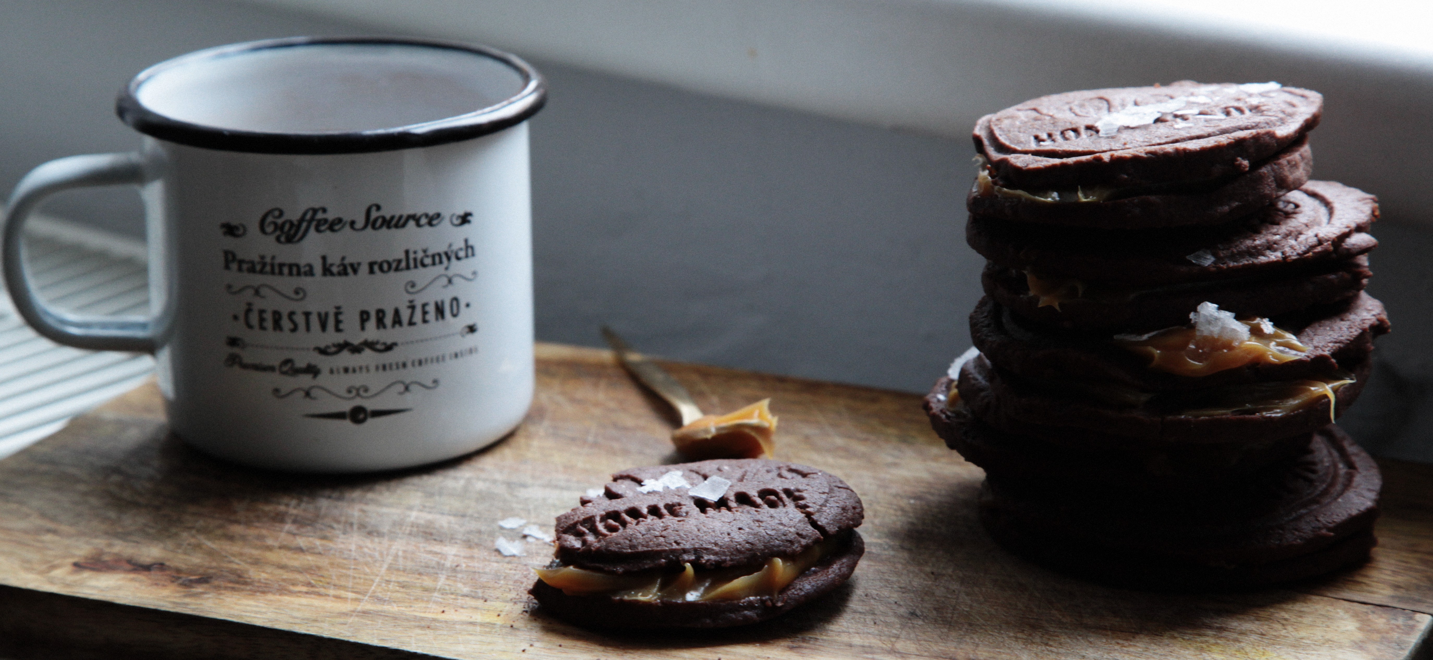 Chocolate cookies with caramel and salt next to a coffee mug HD Wallpaper