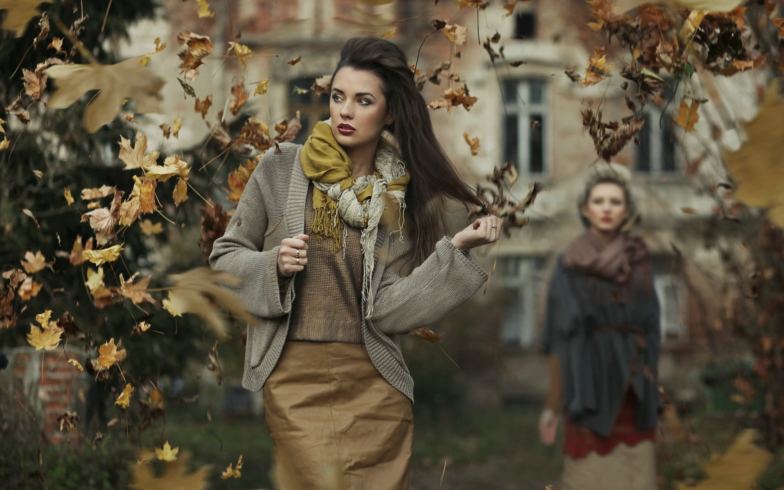 Two women in autumn clothing with falling leaves HD Wallpaper