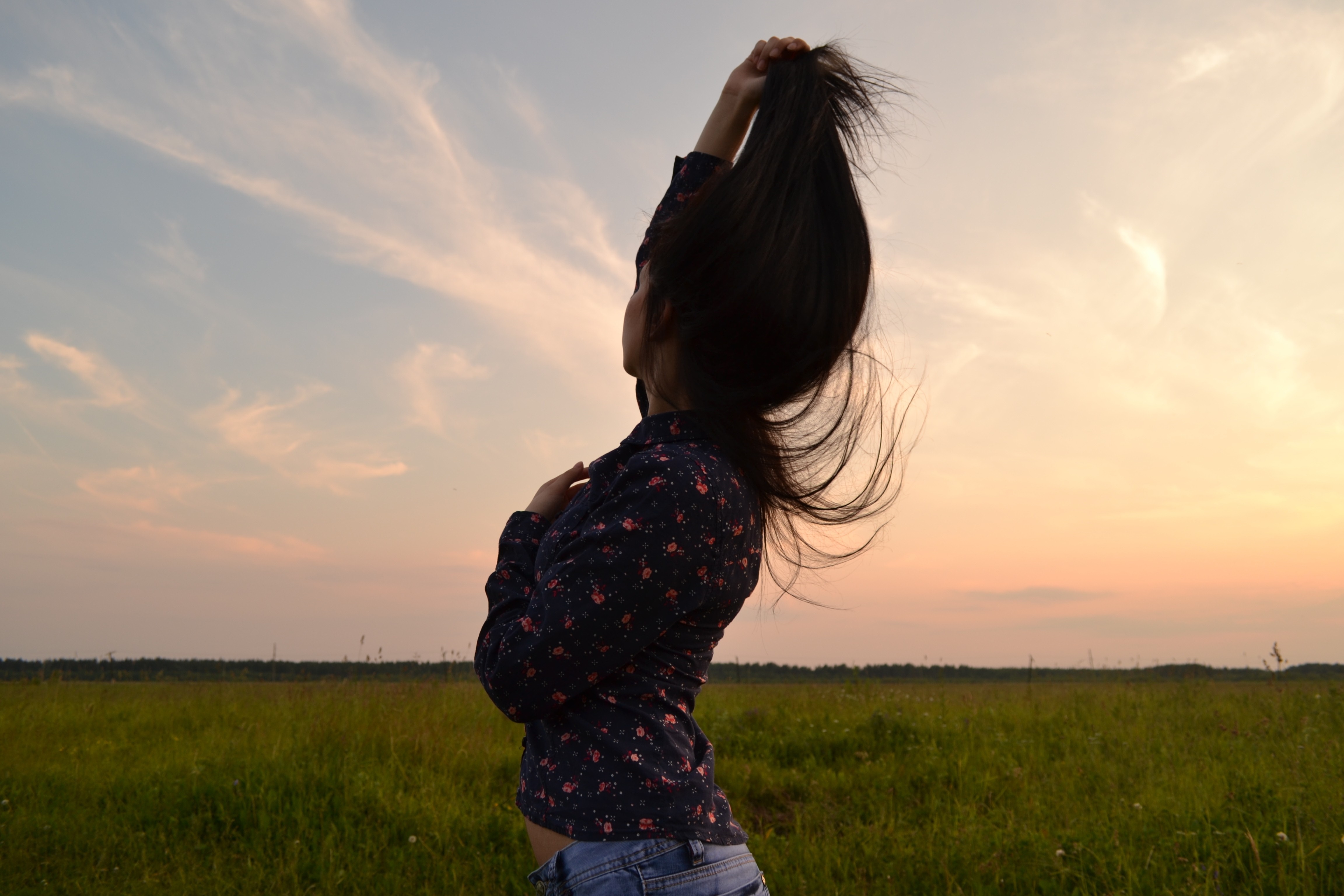 Woman with long hair in a field at sunset HD Wallpaper