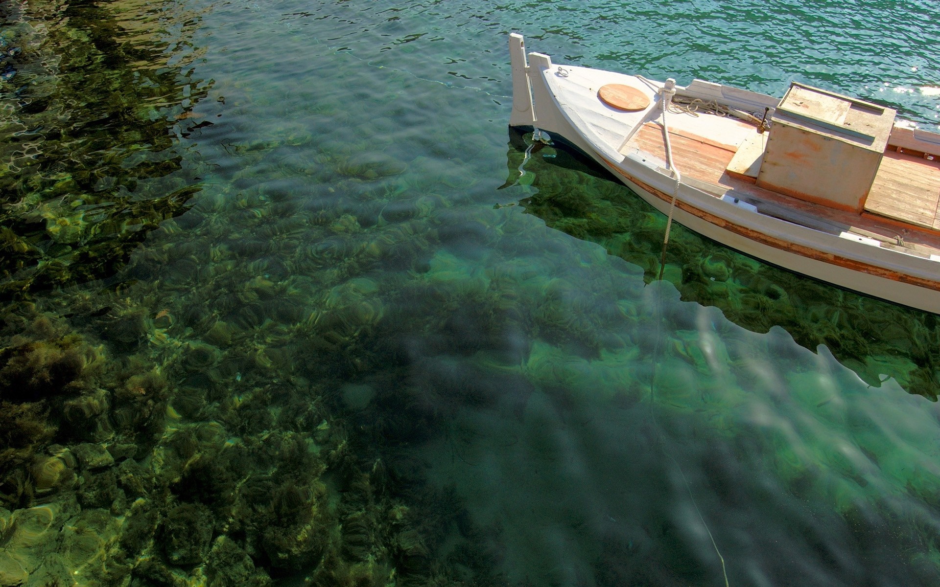 White boat floating on clear green water over rocks HD Wallpaper