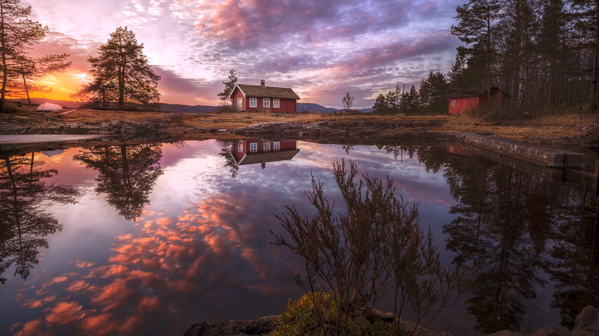 Red cabin reflected in a lake at sunset HD Wallpaper