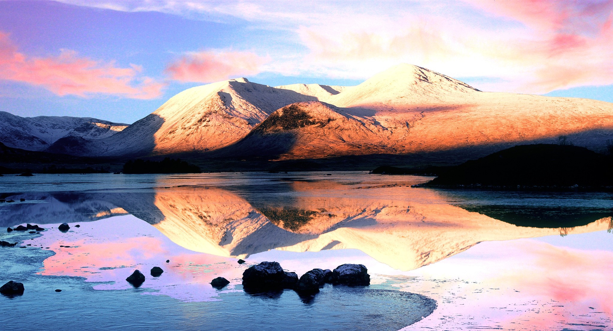 Snow-capped mountains reflected in a lake at sunset HD Wallpaper