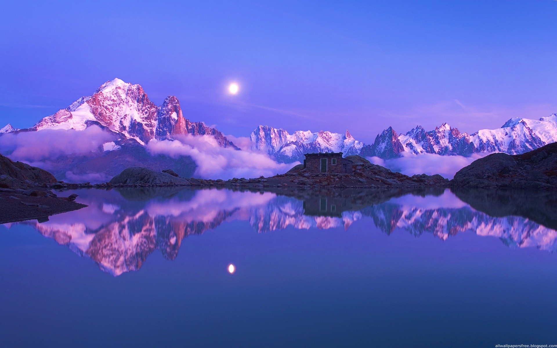 Snow-capped mountains reflected in a lake at dusk HD Wallpaper