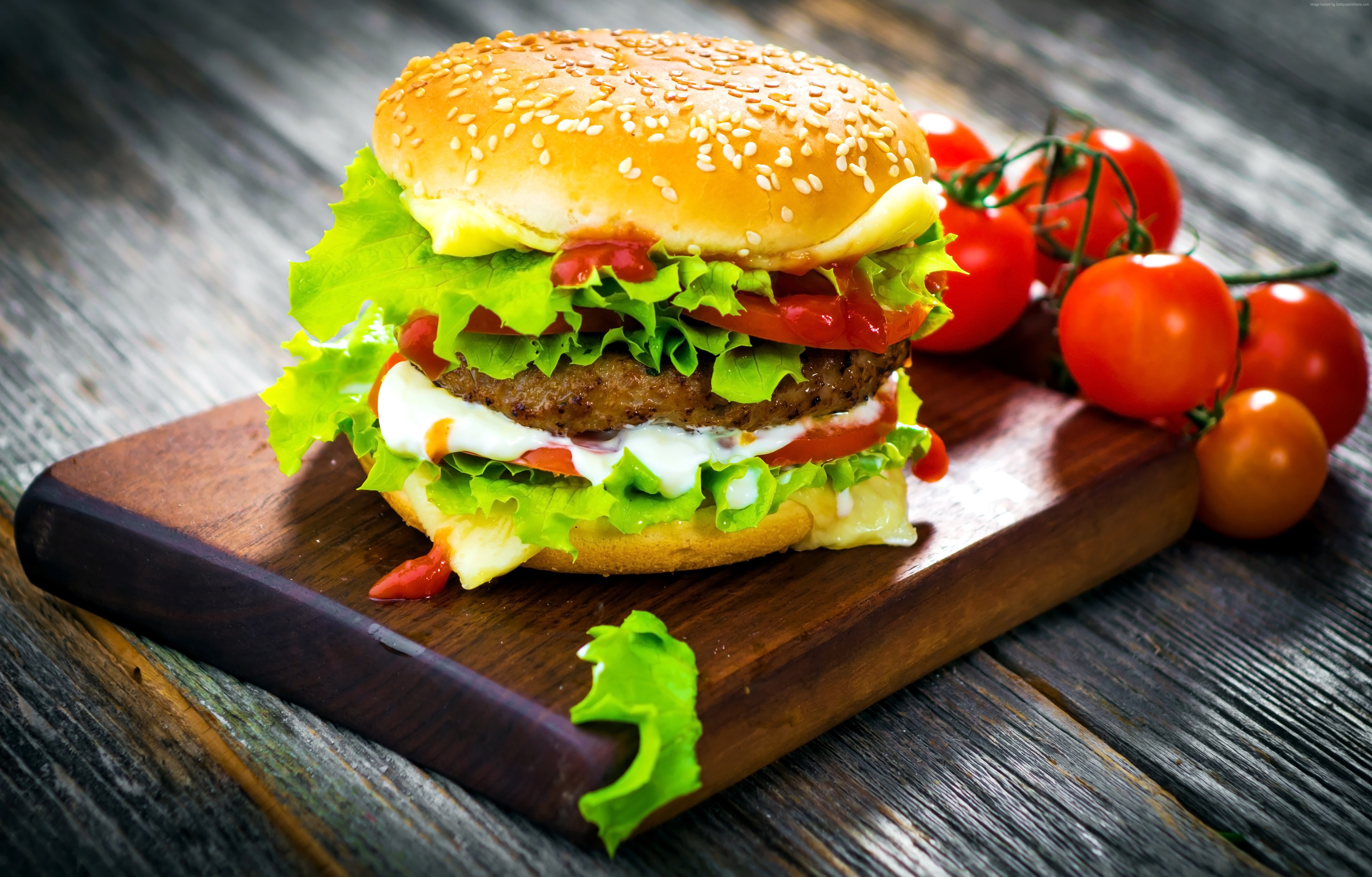 Hamburger with lettuce, tomato, and cheese on a wooden board HD Wallpaper