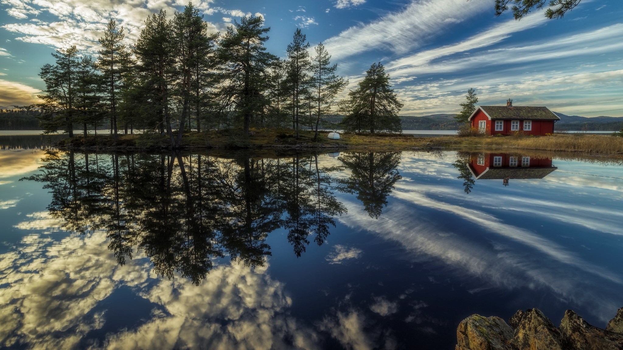 Red cabin reflected in a calm lake with trees and clouds HD Wallpaper