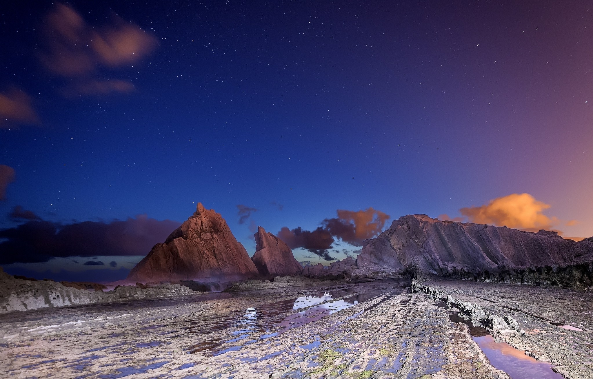 Rocky coastline under starry night sky HD Wallpaper