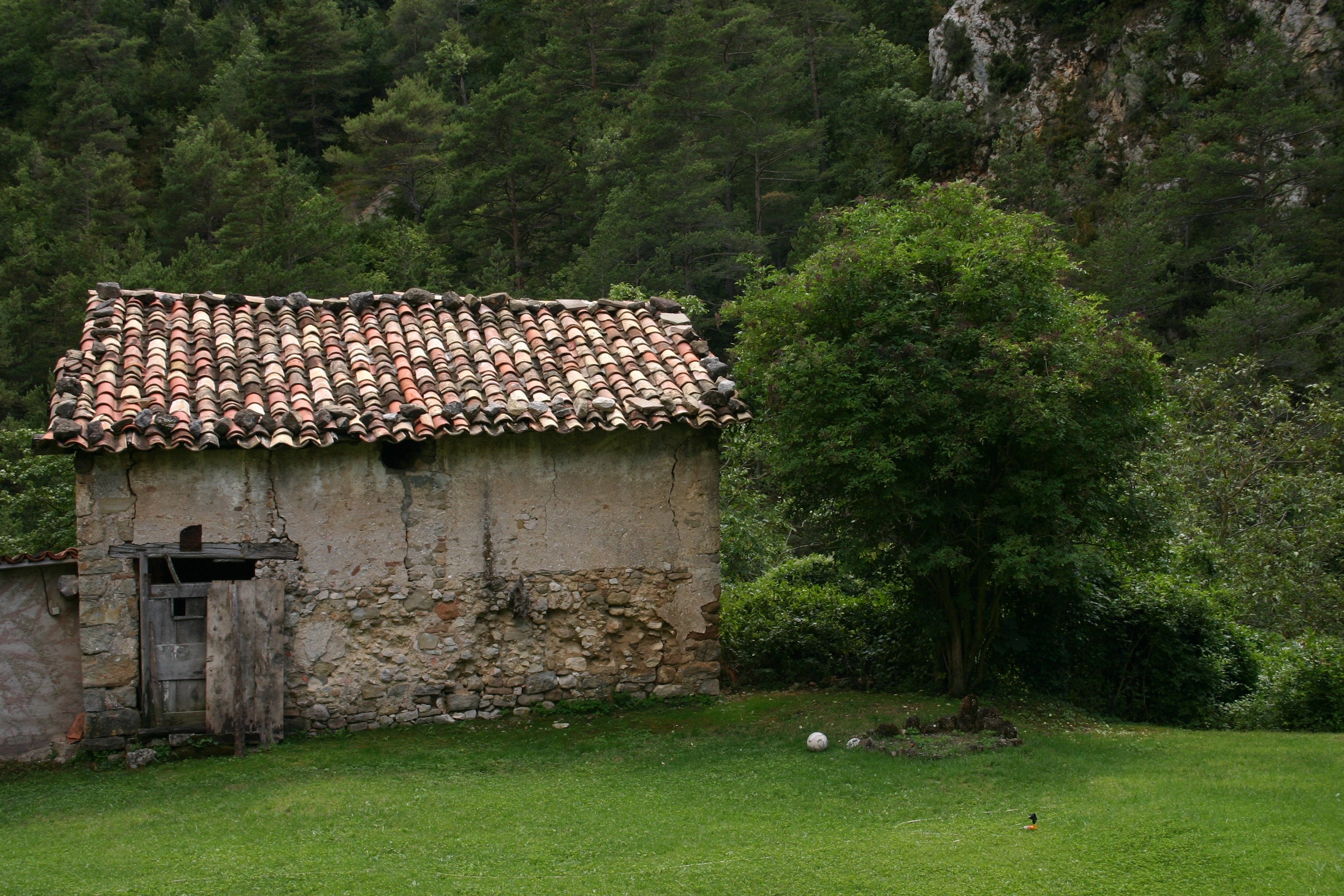Old stone house with tiled roof in a rural landscape HD Wallpaper
