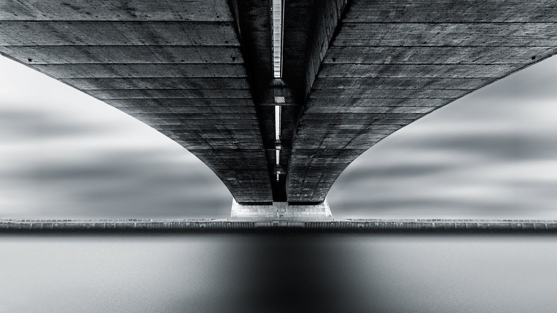 Underneath a concrete bridge with water reflection HD Wallpaper