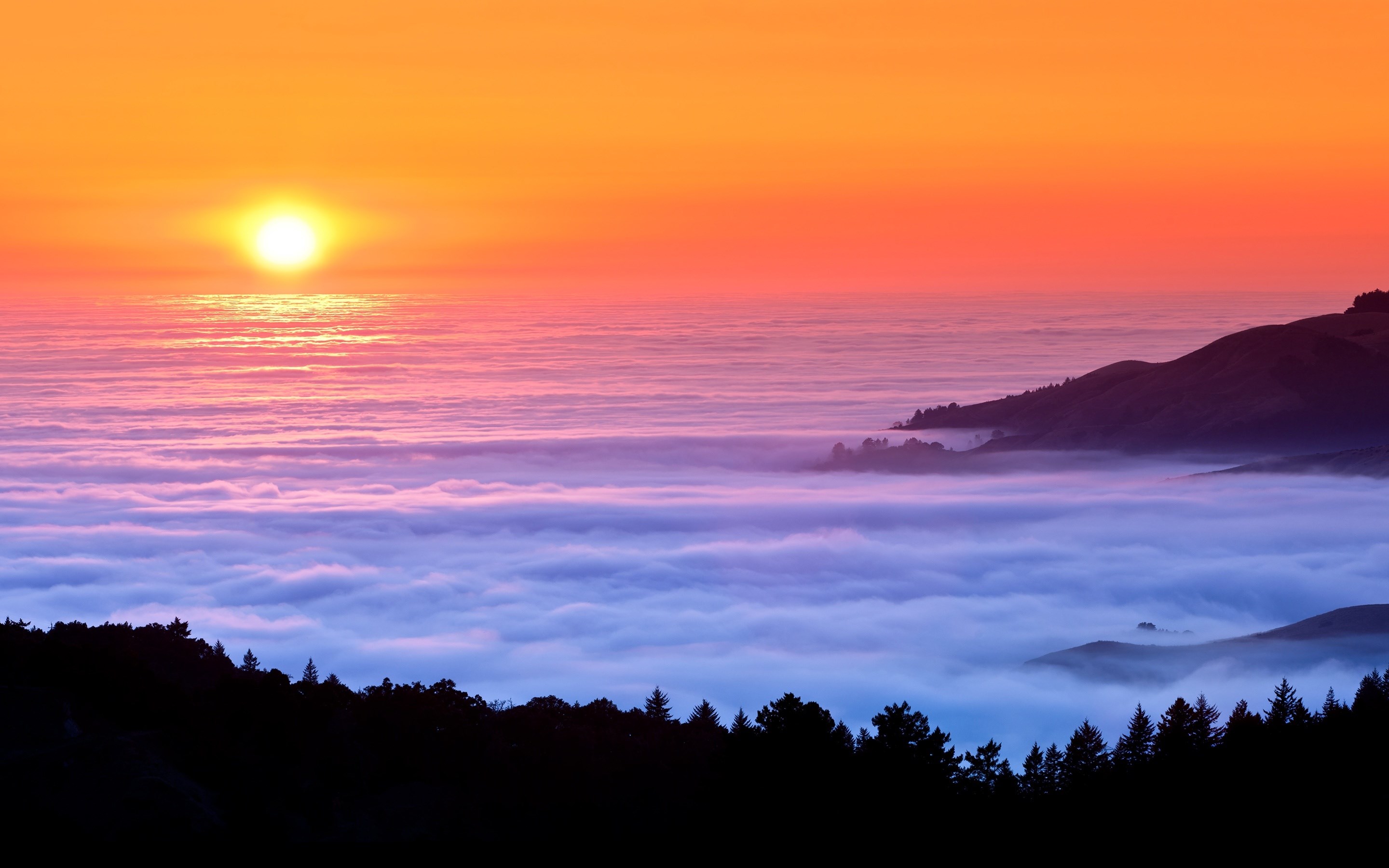 Sunset over ocean fog and silhouetted hills HD Wallpaper