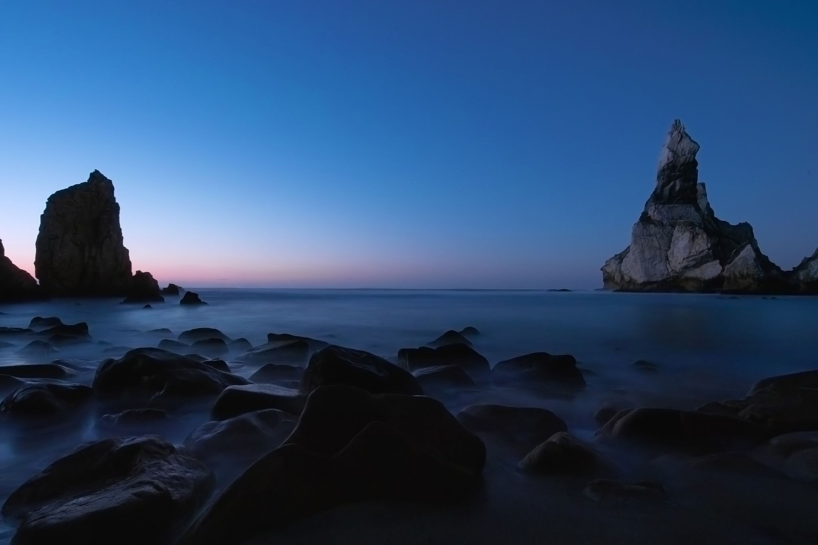 Rocky coastline at dusk with ocean waves HD Wallpaper