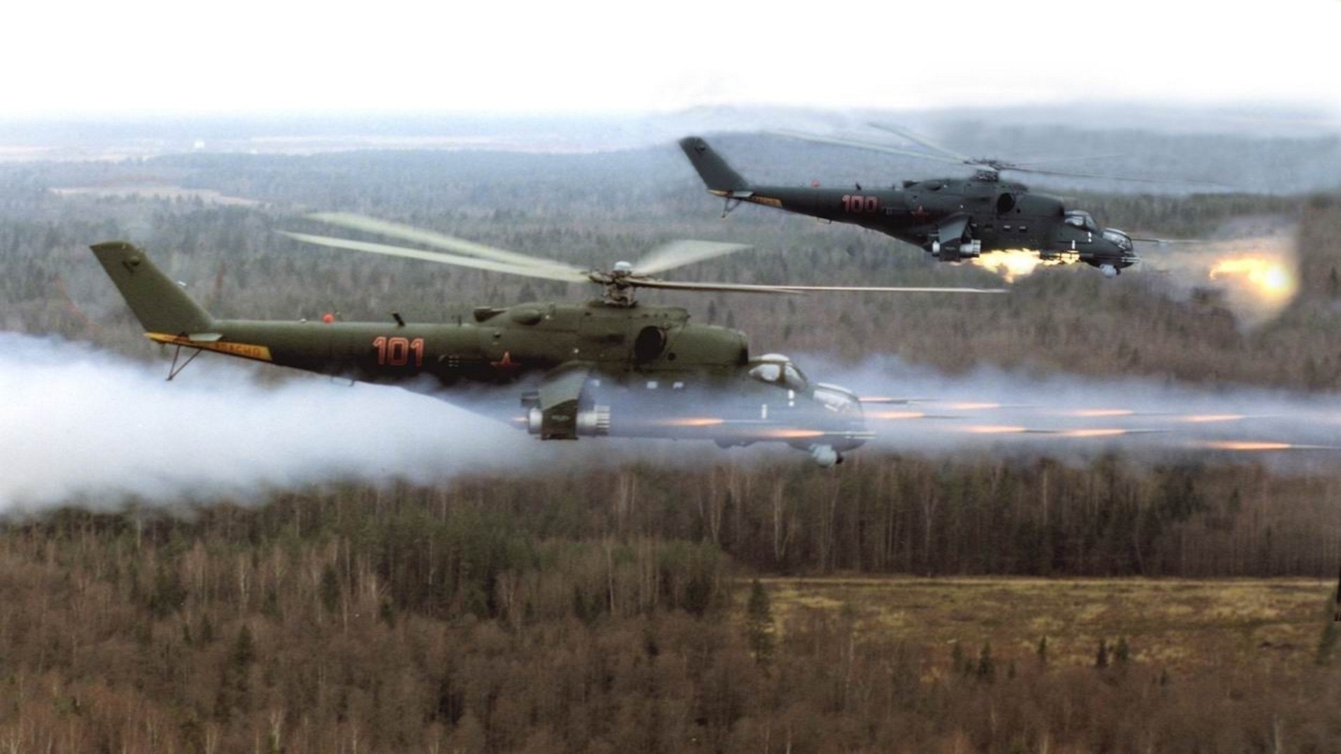 Two Mi-24 helicopters firing weapons over a forest HD Wallpaper