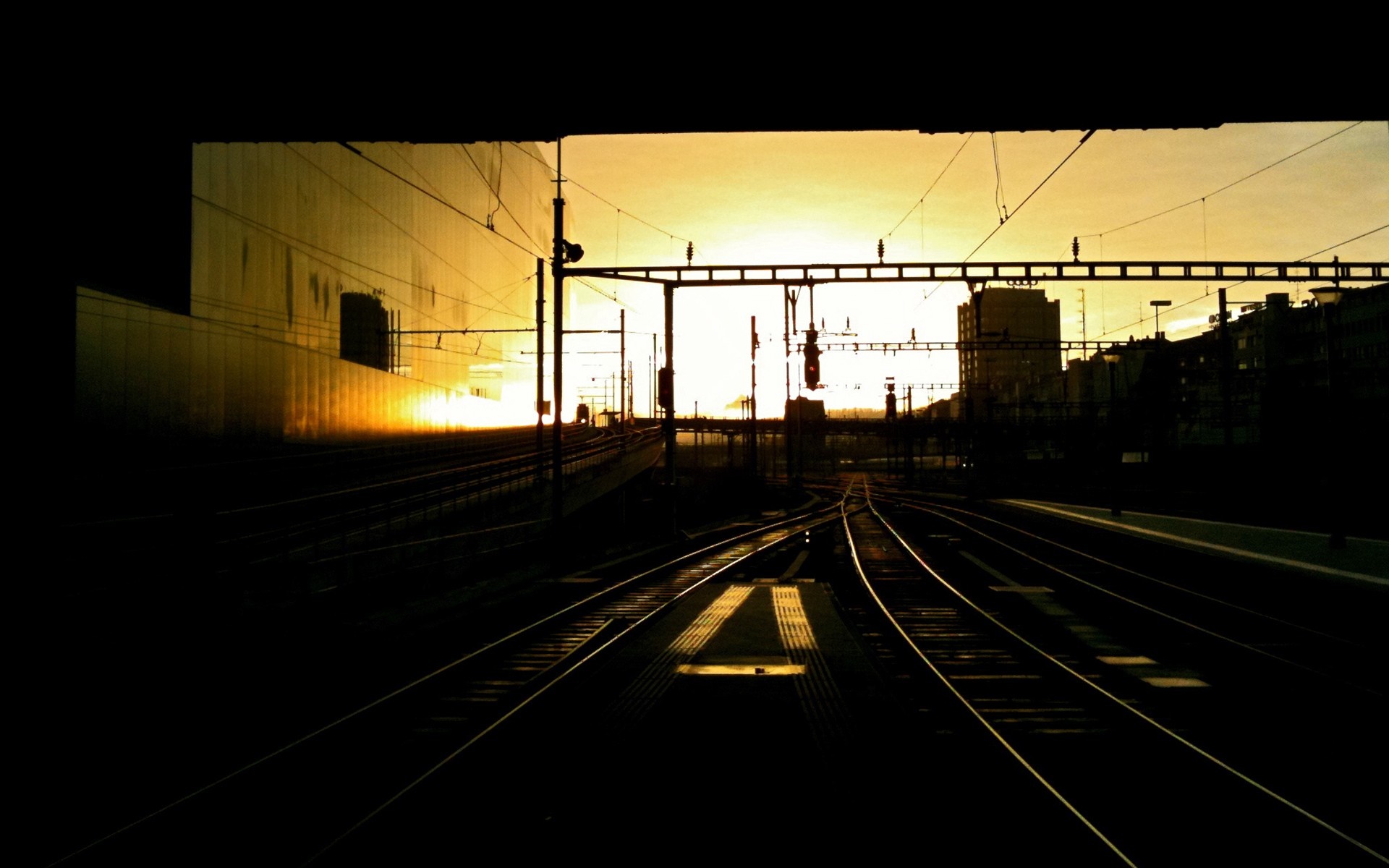 Train tracks at sunset with city buildings HD Wallpaper