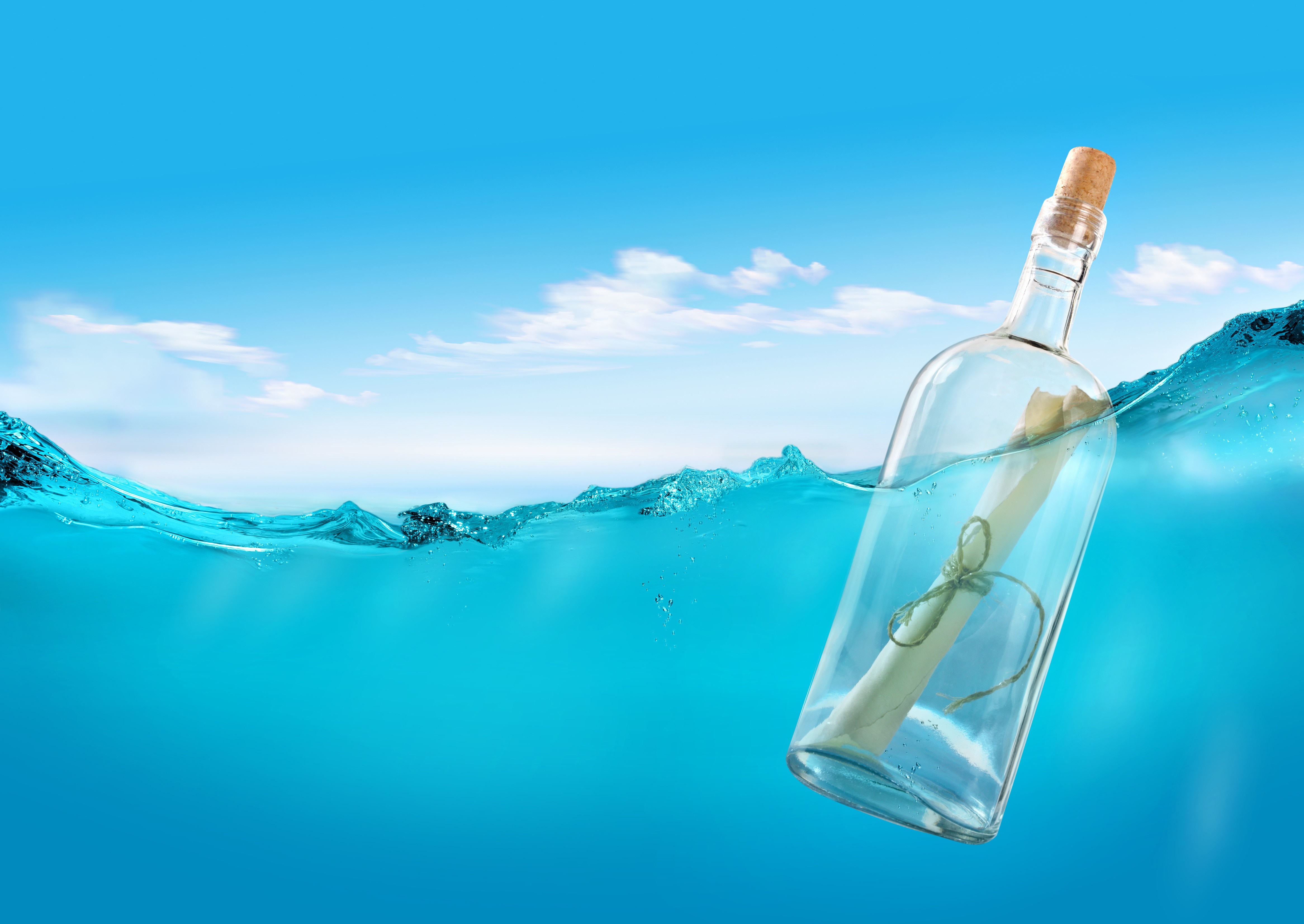 Message in a bottle floating in water under blue sky HD Wallpaper