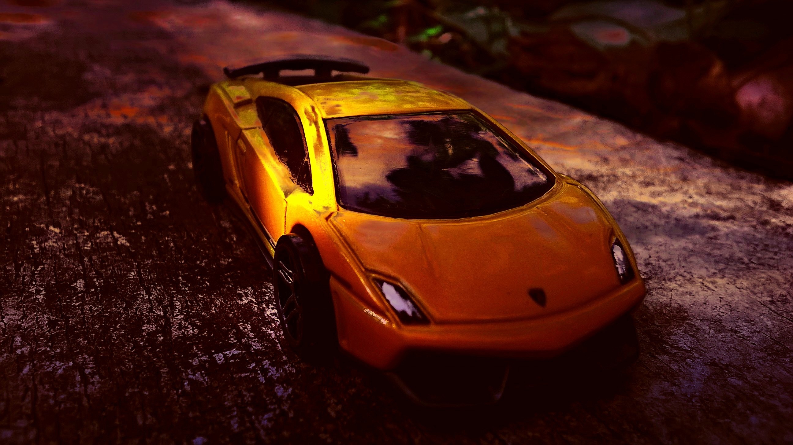 Yellow Lamborghini toy car on a textured surface HD Wallpaper