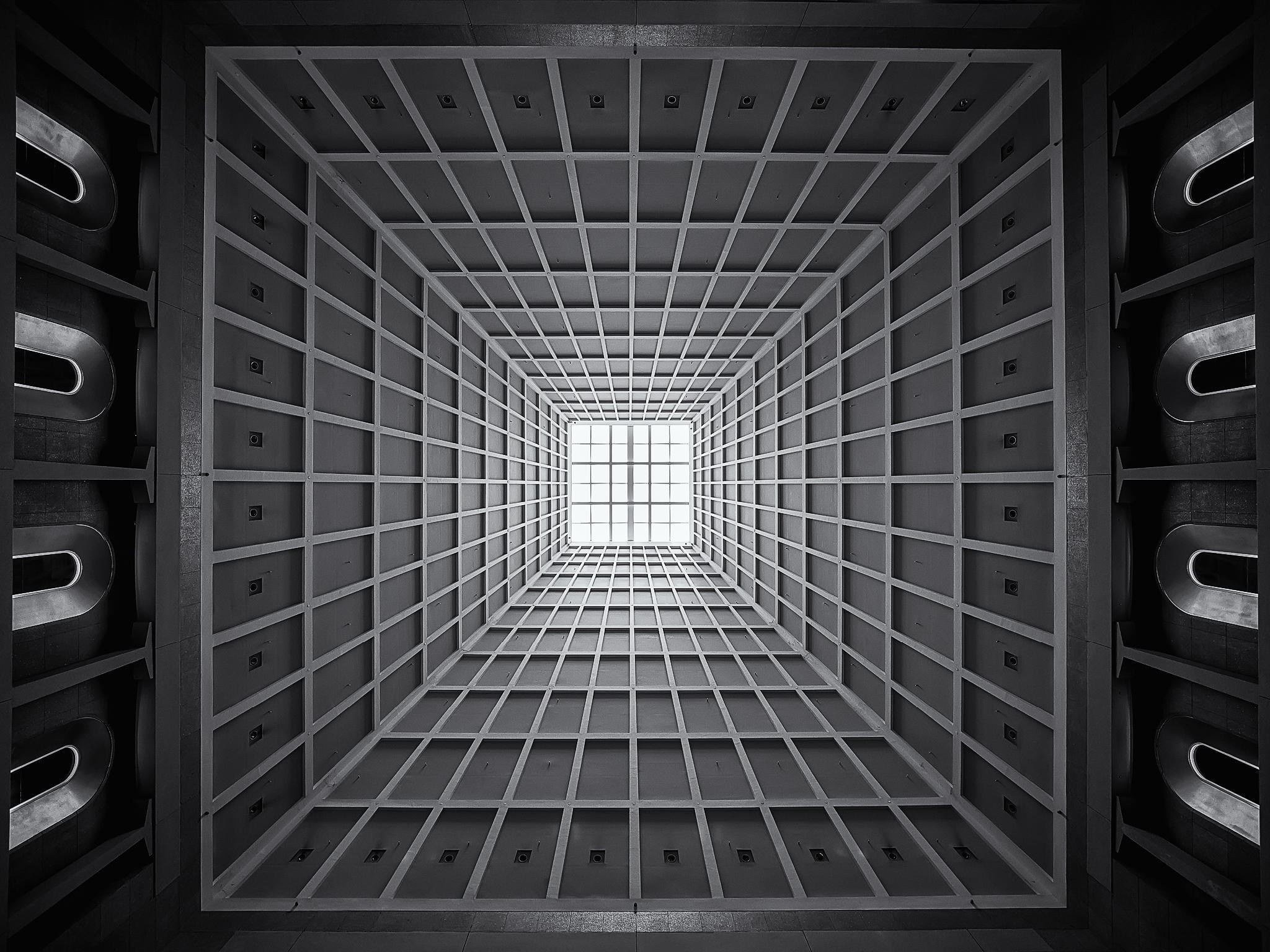Monochrome view of a modern building interior with a grid ceiling HD Wallpaper