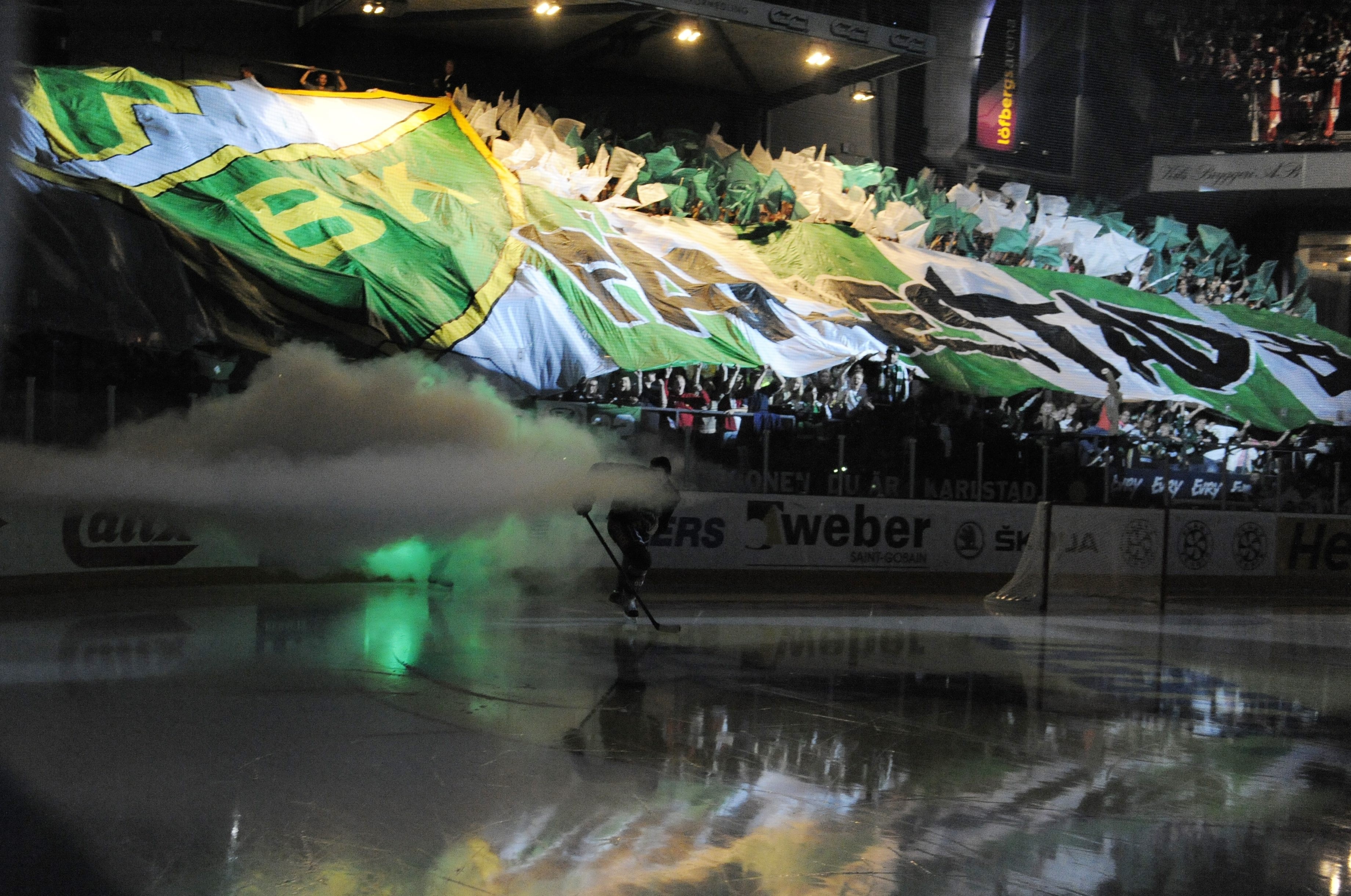 Ice hockey players and fans with banners and smoke HD Wallpaper