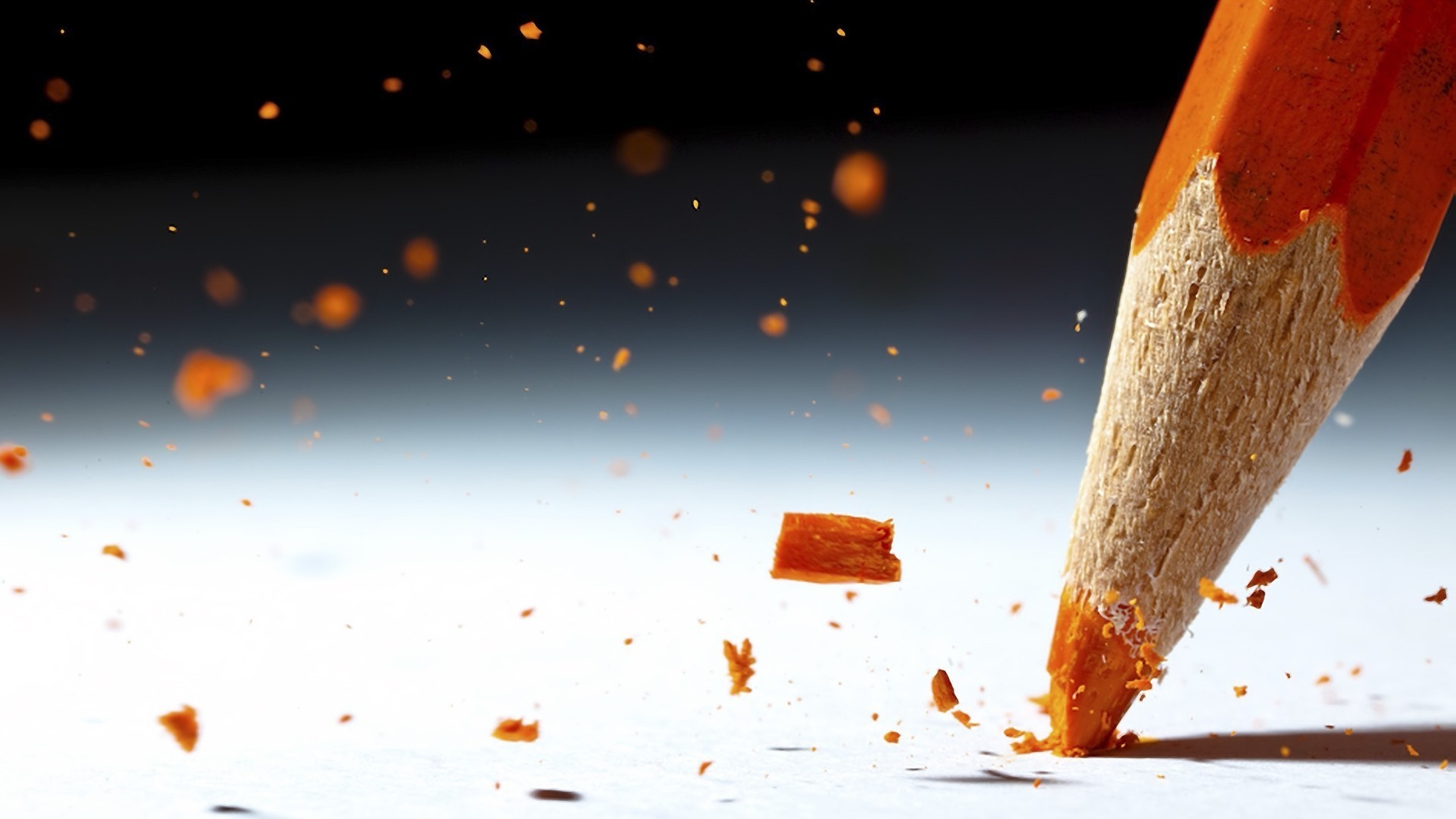 Close-up of orange pencil breaking on white surface HD Wallpaper