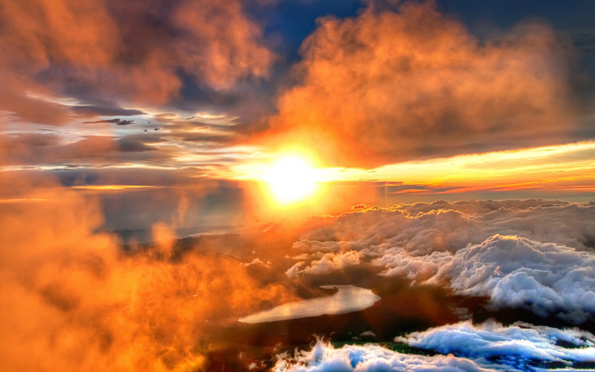 Sunrise over clouds with a lake below HD Wallpaper