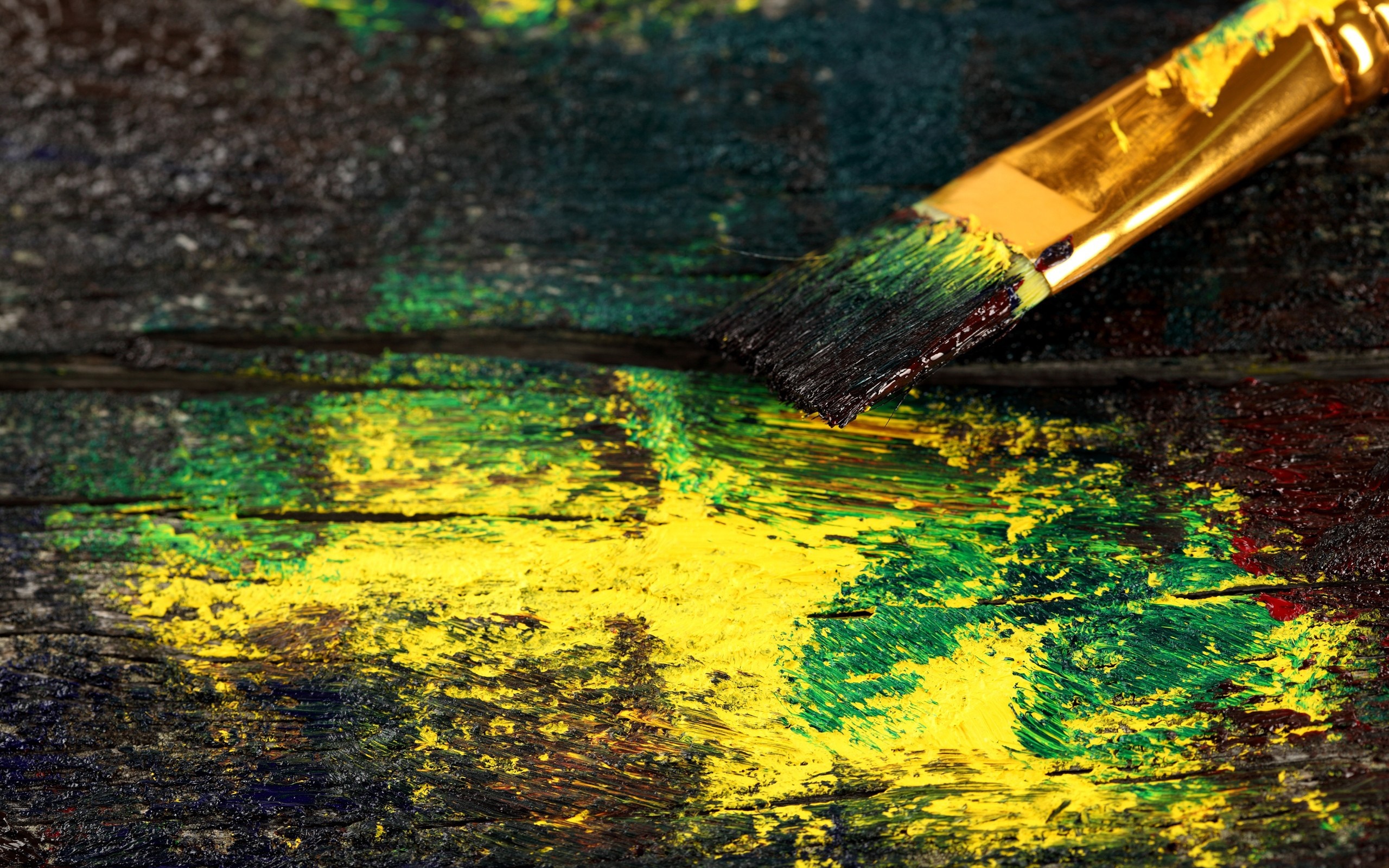 Paintbrush with yellow and green paint on wood HD Wallpaper