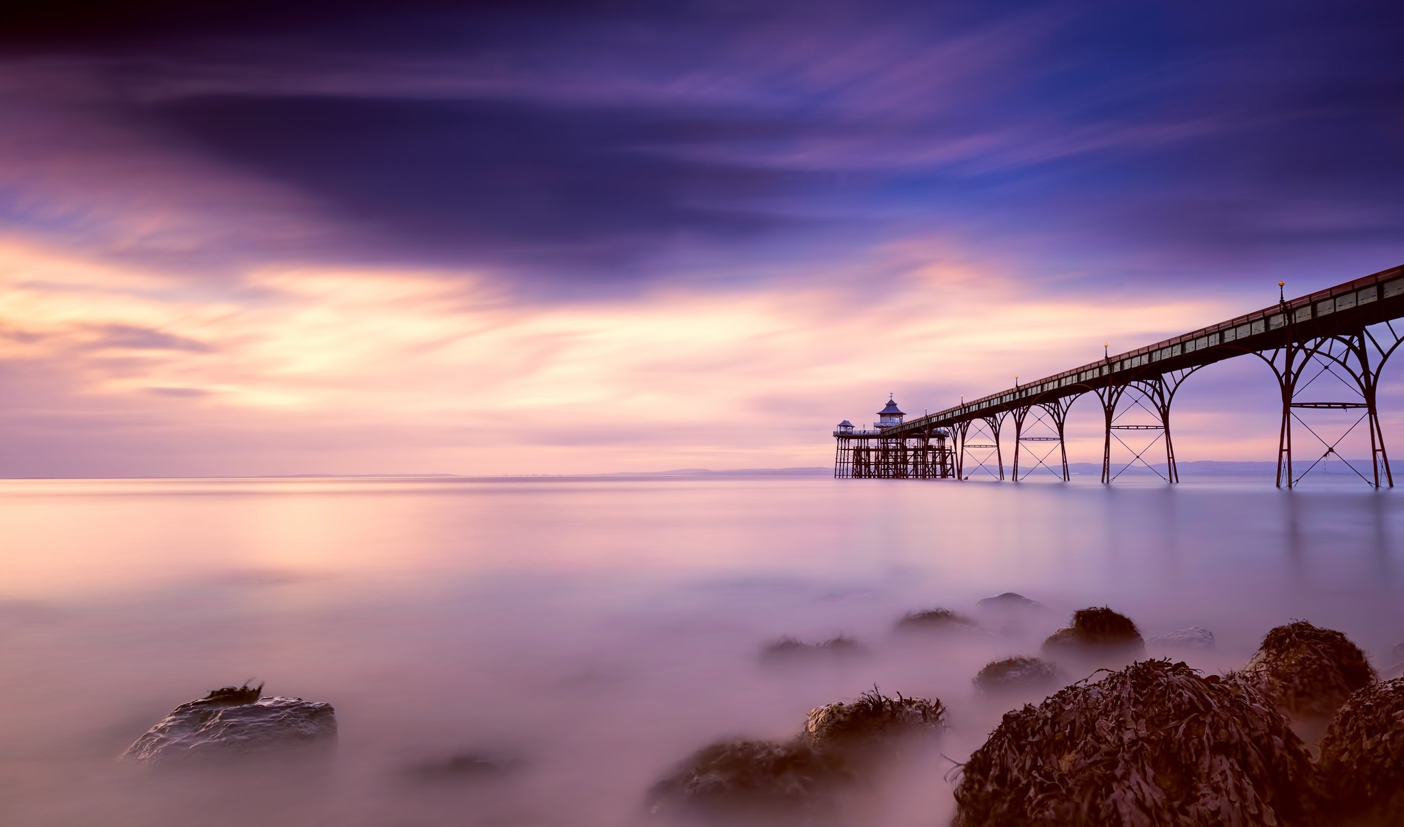 Long exposure of a pier at sunset over the sea HD Wallpaper