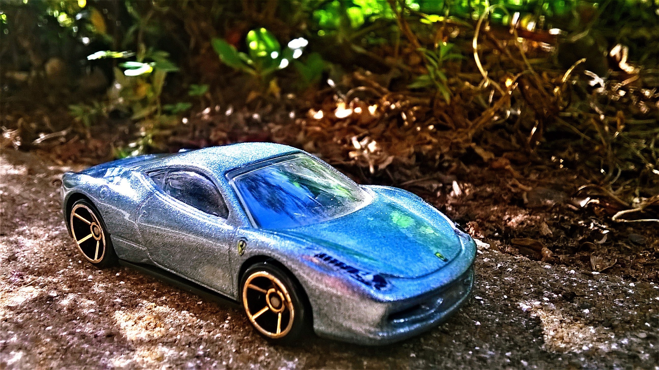Blue Ferrari 458 Italia toy car on dirt path HD Wallpaper