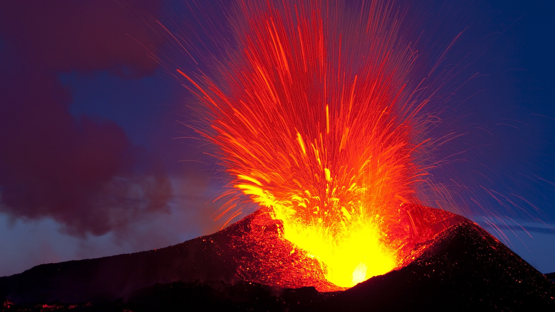 Volcano erupting with lava and ash at night HD Wallpaper