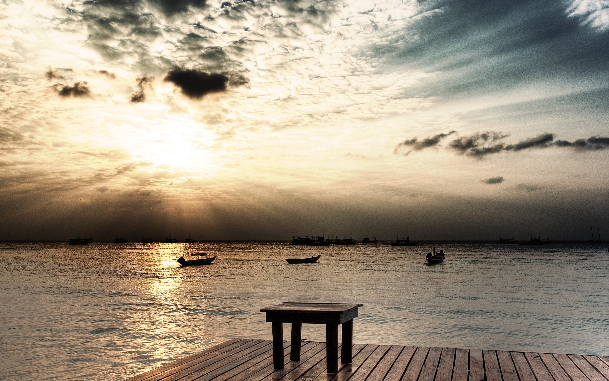 Sunset over the ocean with boats and a pier HD Wallpaper