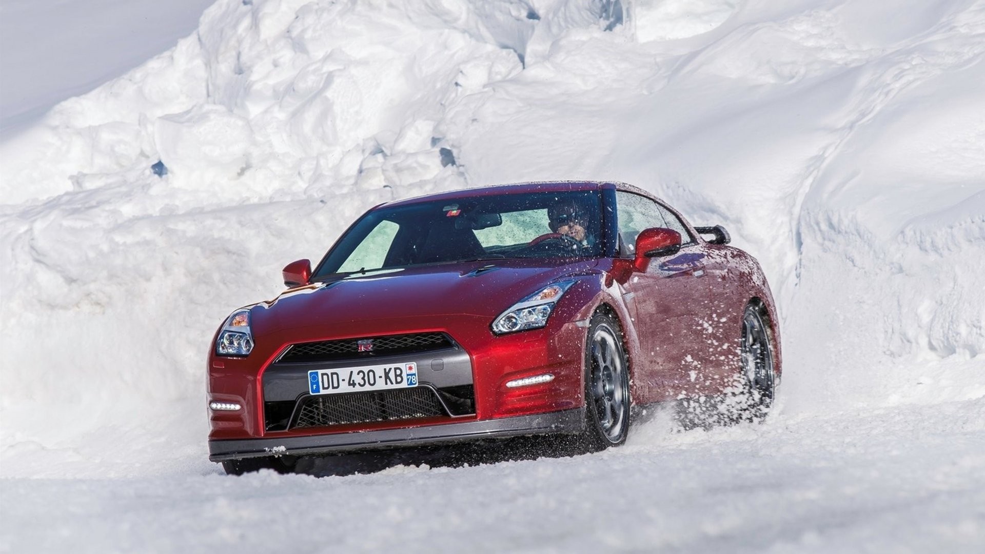 Red Nissan GT-R driving through snow HD Wallpaper