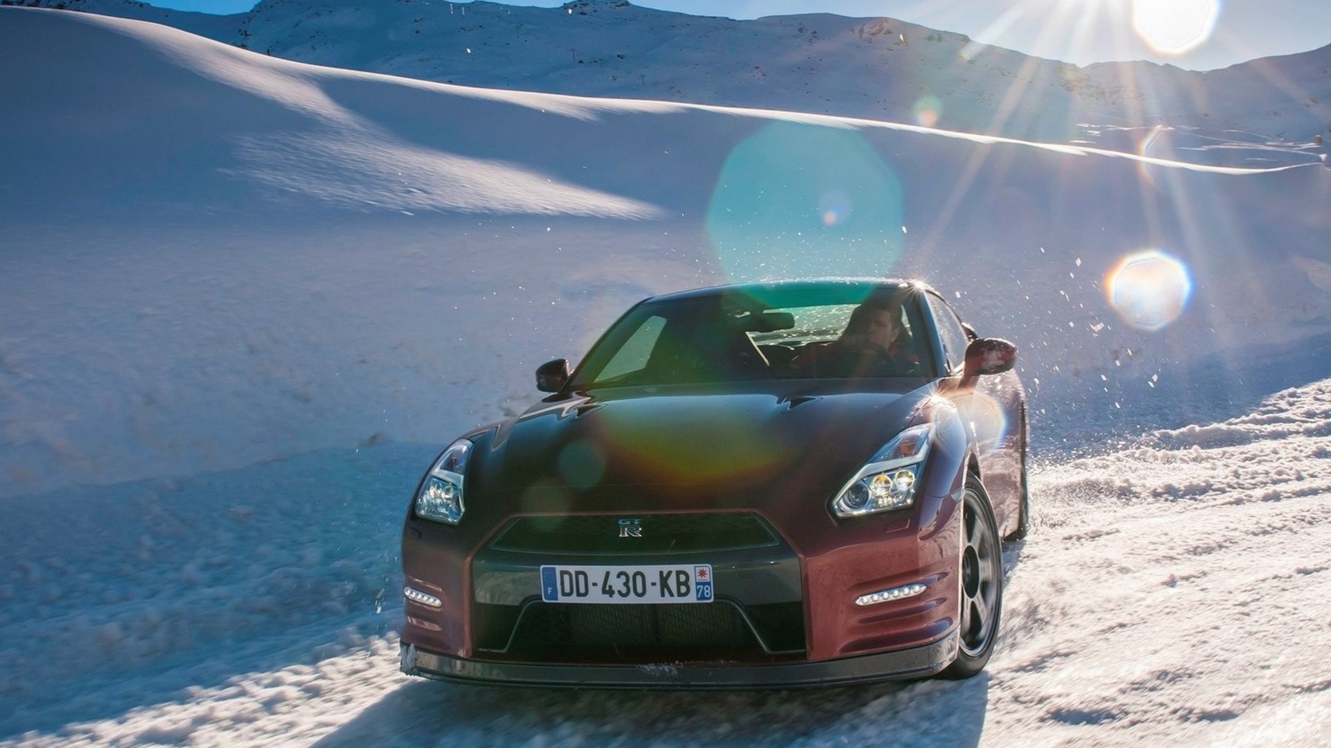 Nissan GT-R driving on a snowy mountain road HD Wallpaper