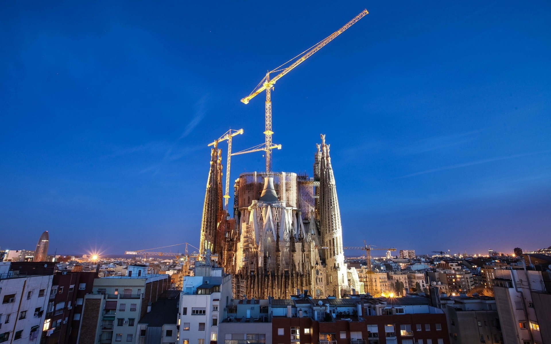 Sagrada Familia under construction with cranes at night HD Wallpaper