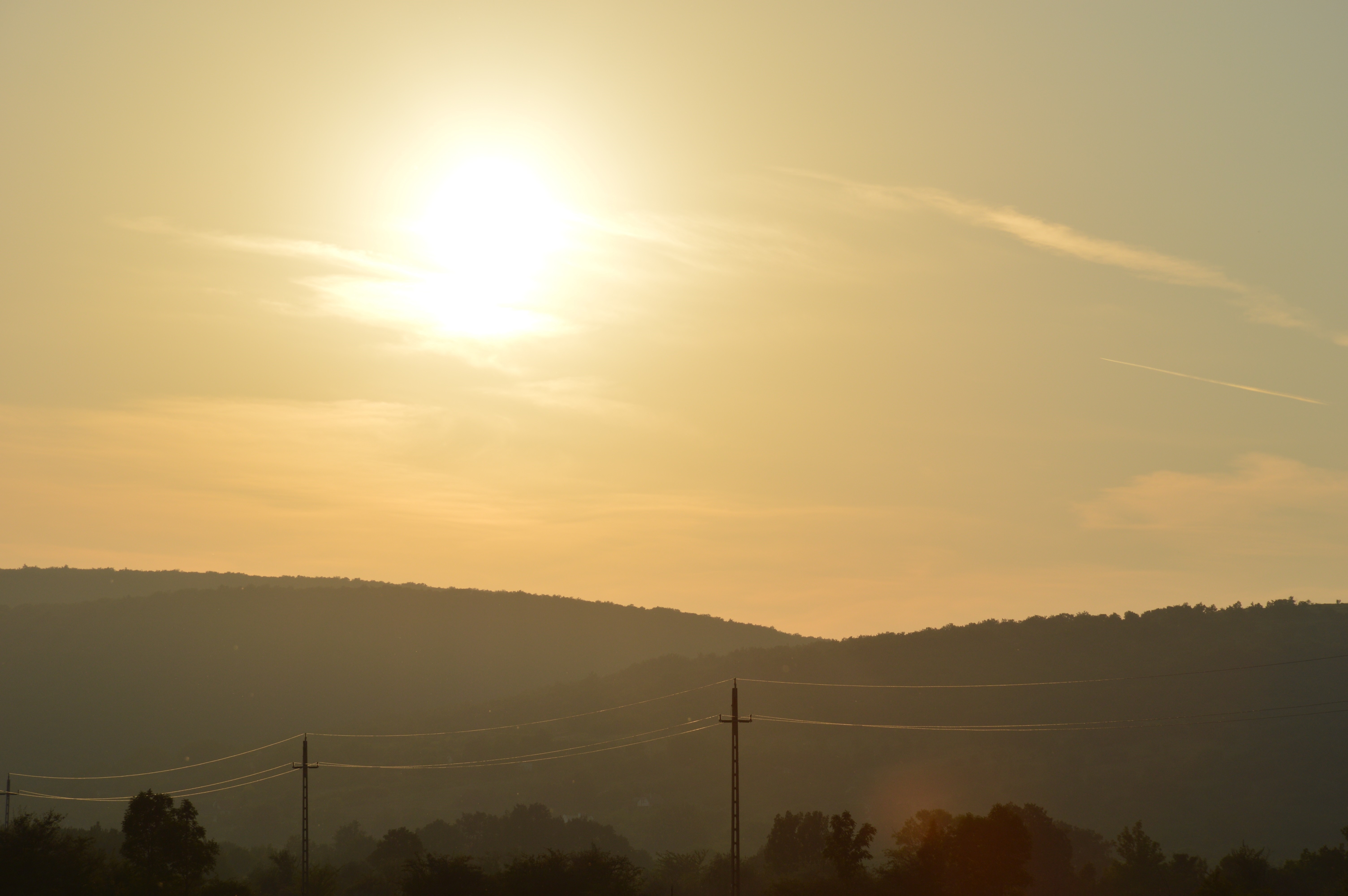 Sun setting over rolling hills with power lines HD Wallpaper