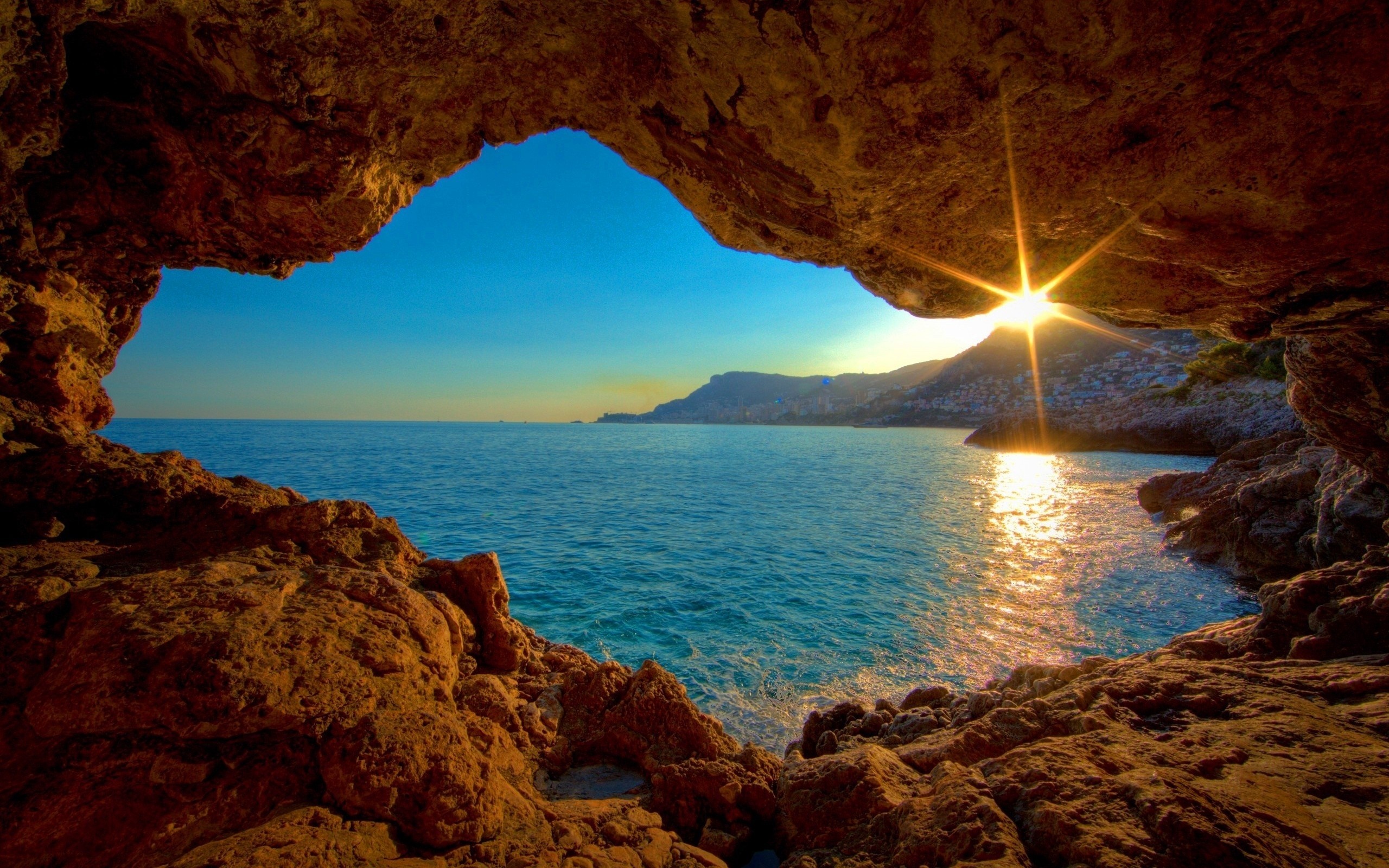 View from a cave of the sea at sunset HD Wallpaper