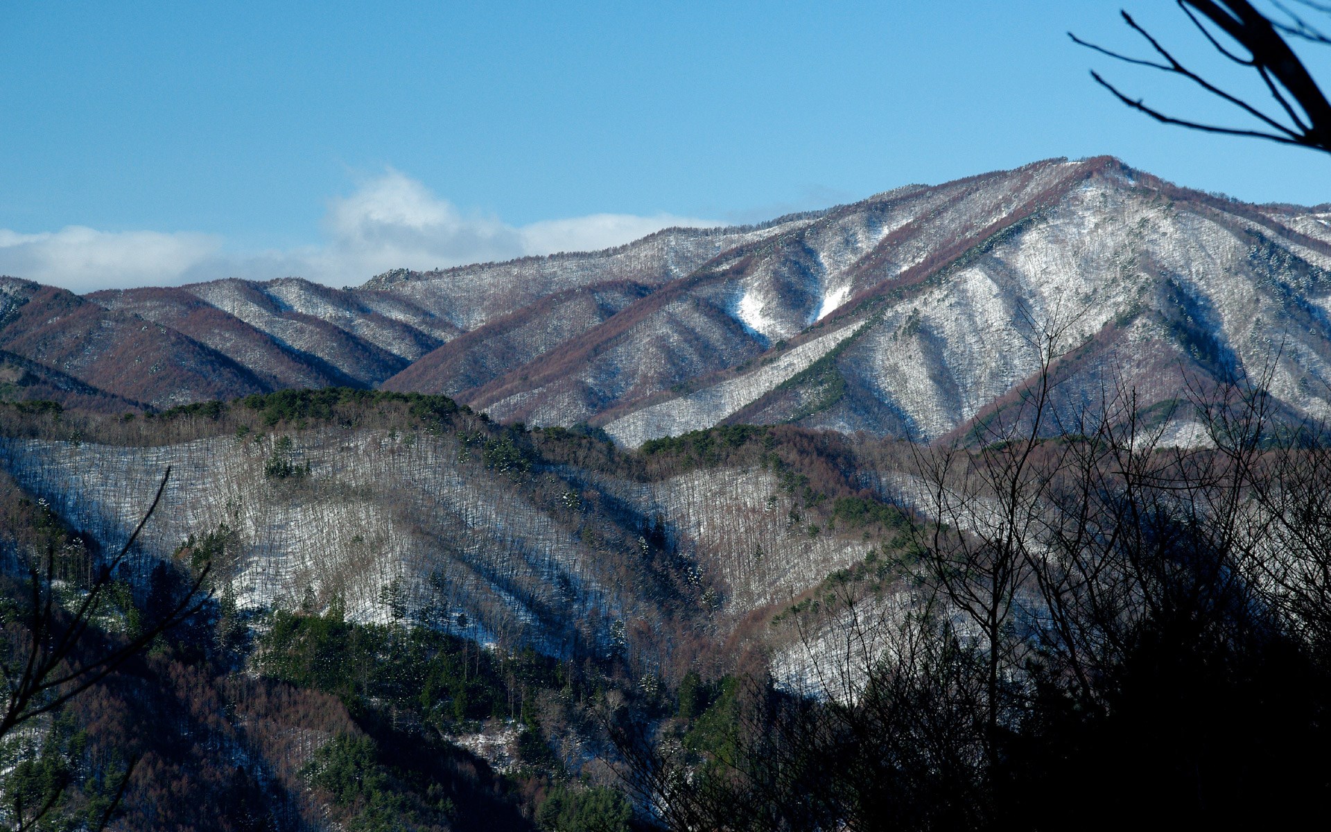 Snow-dusted mountains under a clear blue sky HD Wallpaper