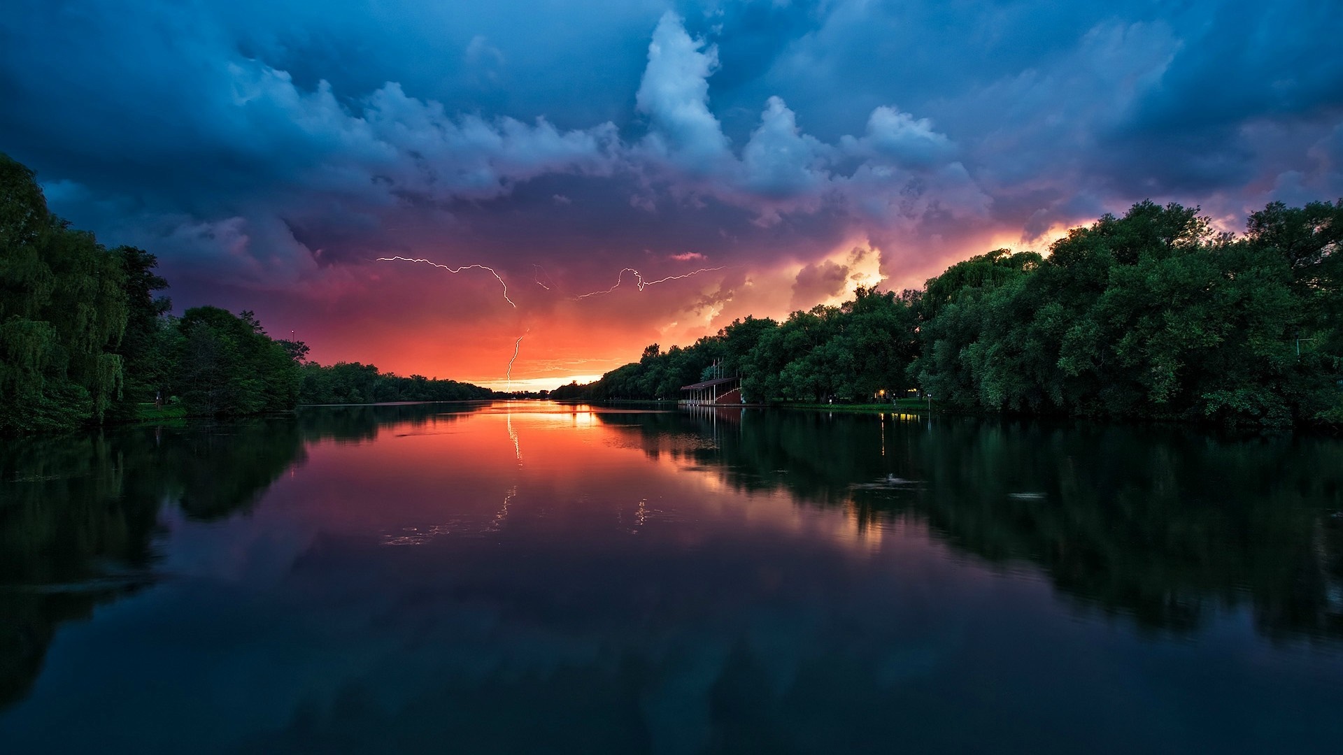 Lightning strikes over a lake at sunset with reflections HD Wallpaper